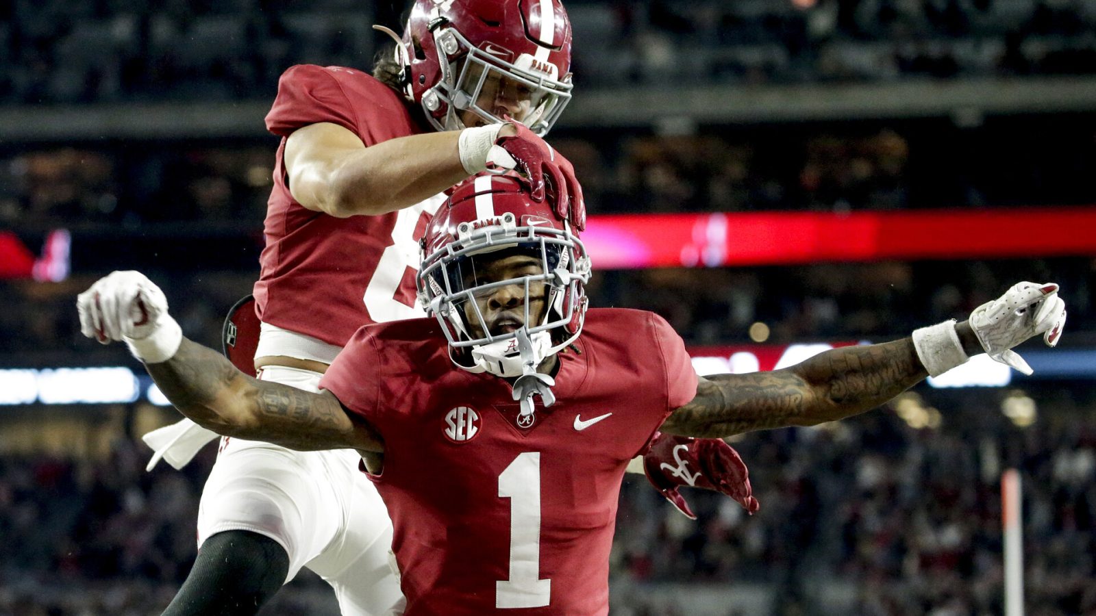 Alabama Crimson Tide wide receiver Jameson Williams (1) celebrates with Alabama Crimson Tide tight end Cameron Latu (81) after scoring a touchdown against the Arkansas Razorbacks during the second half at Bryant-Denny Stadium.