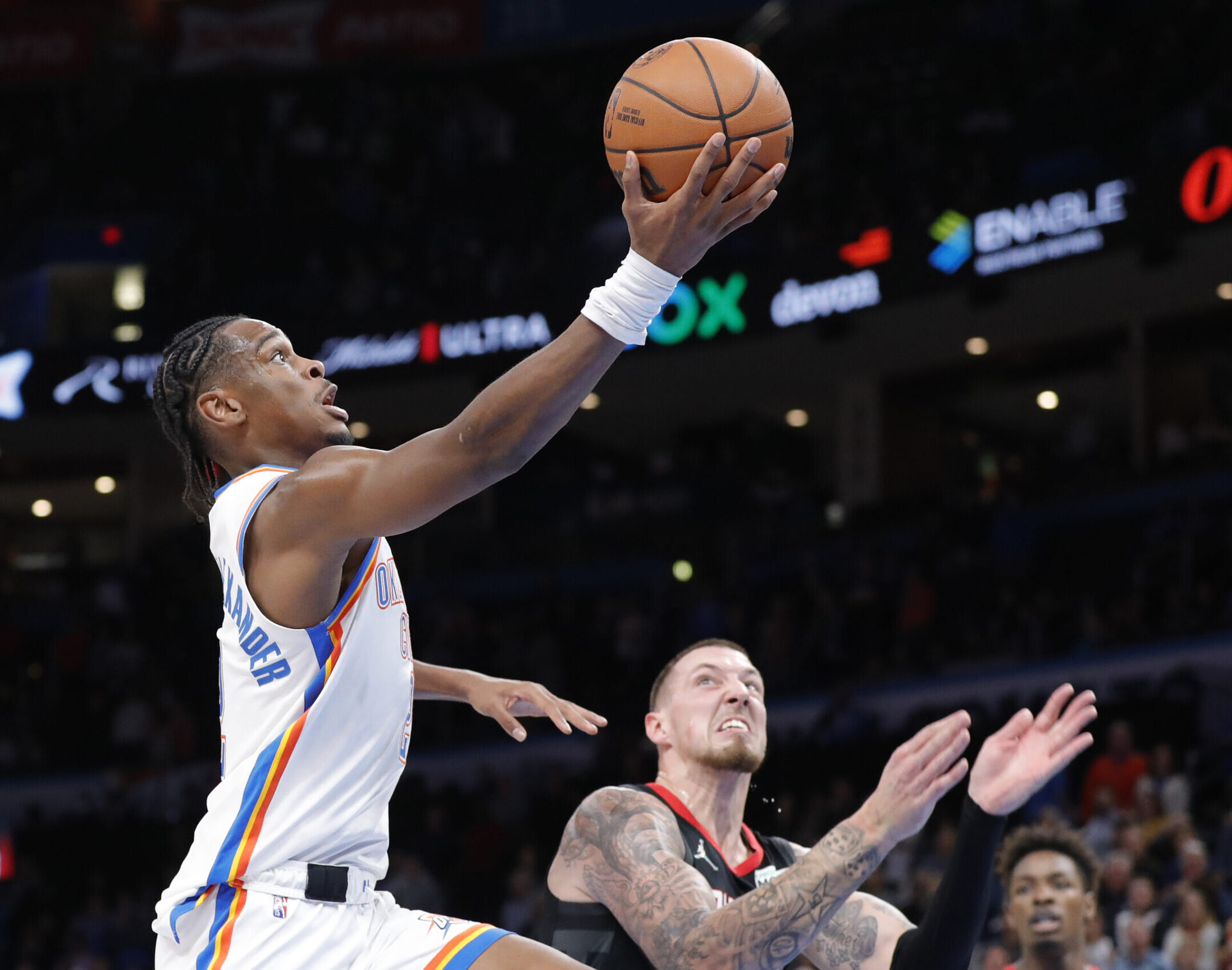 Oklahoma City Thunder guard Shai Gilgeous-Alexander (left) goes up for a basket against Houston Rockets center Daniel Theis (right)