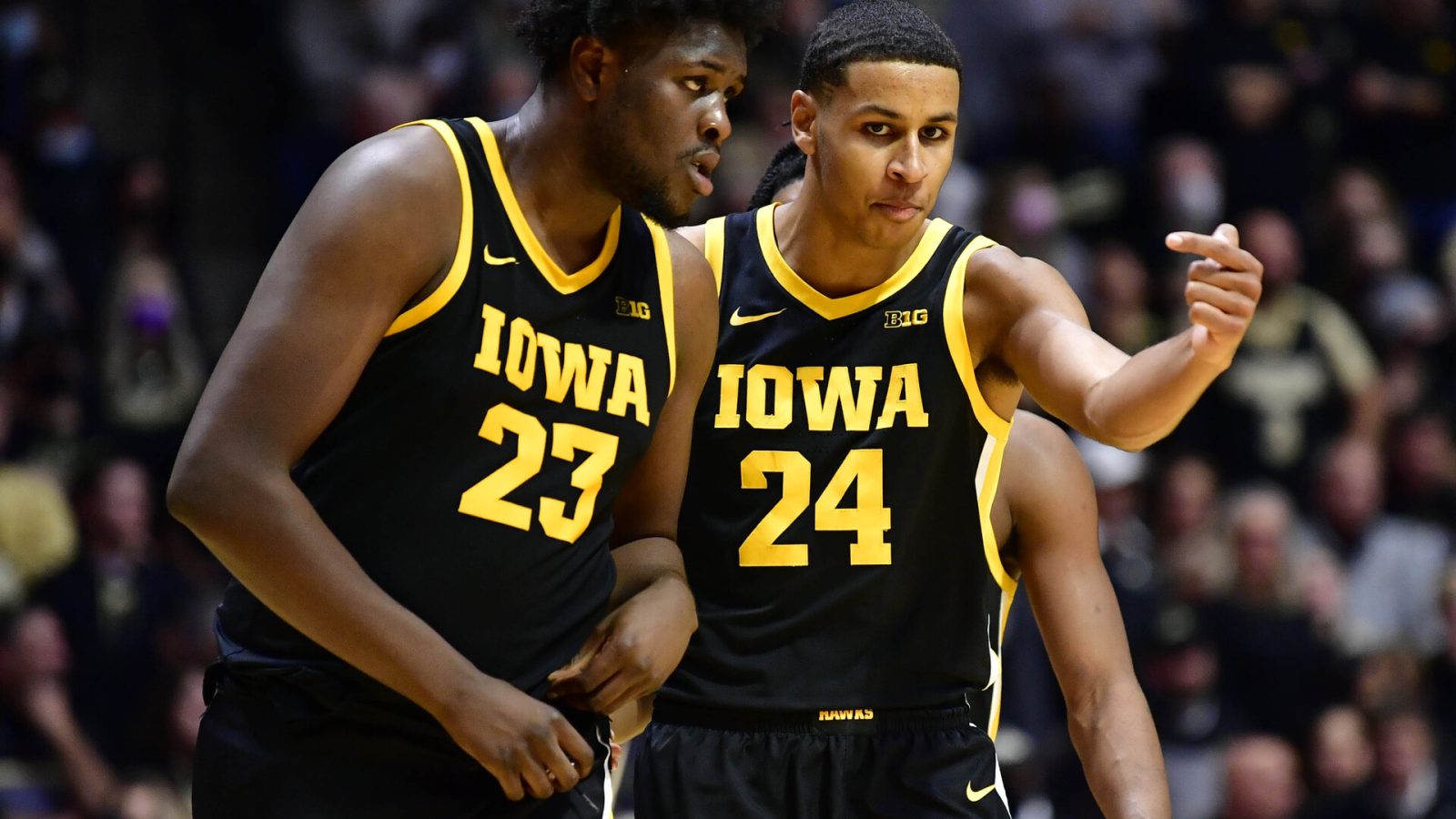 Iowa Hawkeyes forward Josh Ogundele (left) and Iowa Hawkeyes forward Kris Murray (right) have a discussion while walking back onto the court during a game against Purdue
