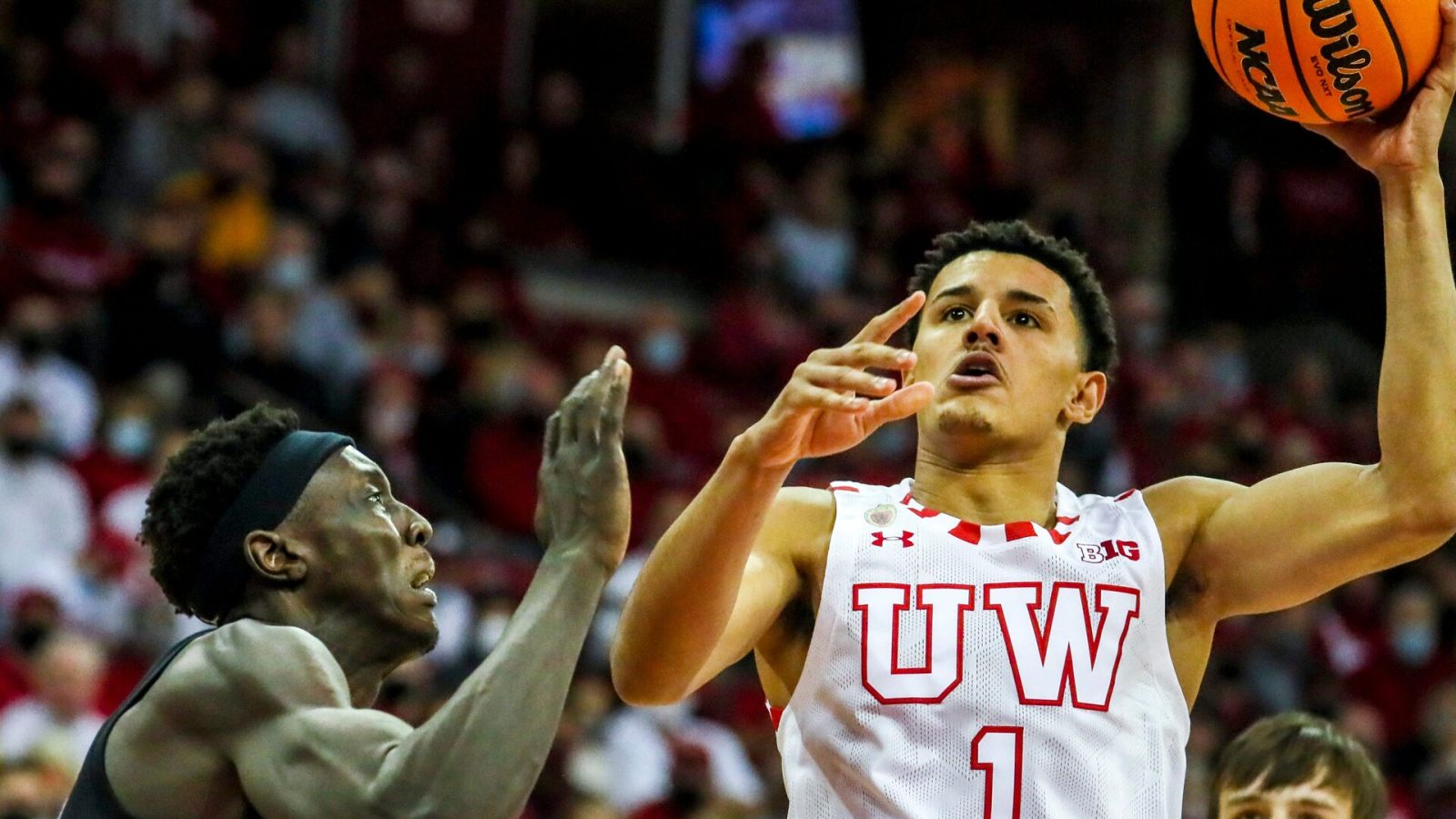 Wisconsin Badgers guard Johnny Davis drives to the basket as Marquette forward Kur Kuath defends