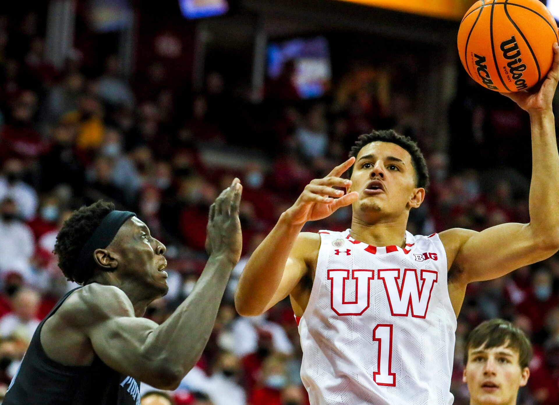 Wisconsin Badgers guard Johnny Davis drives to the basket as Marquette forward Kur Kuath defends