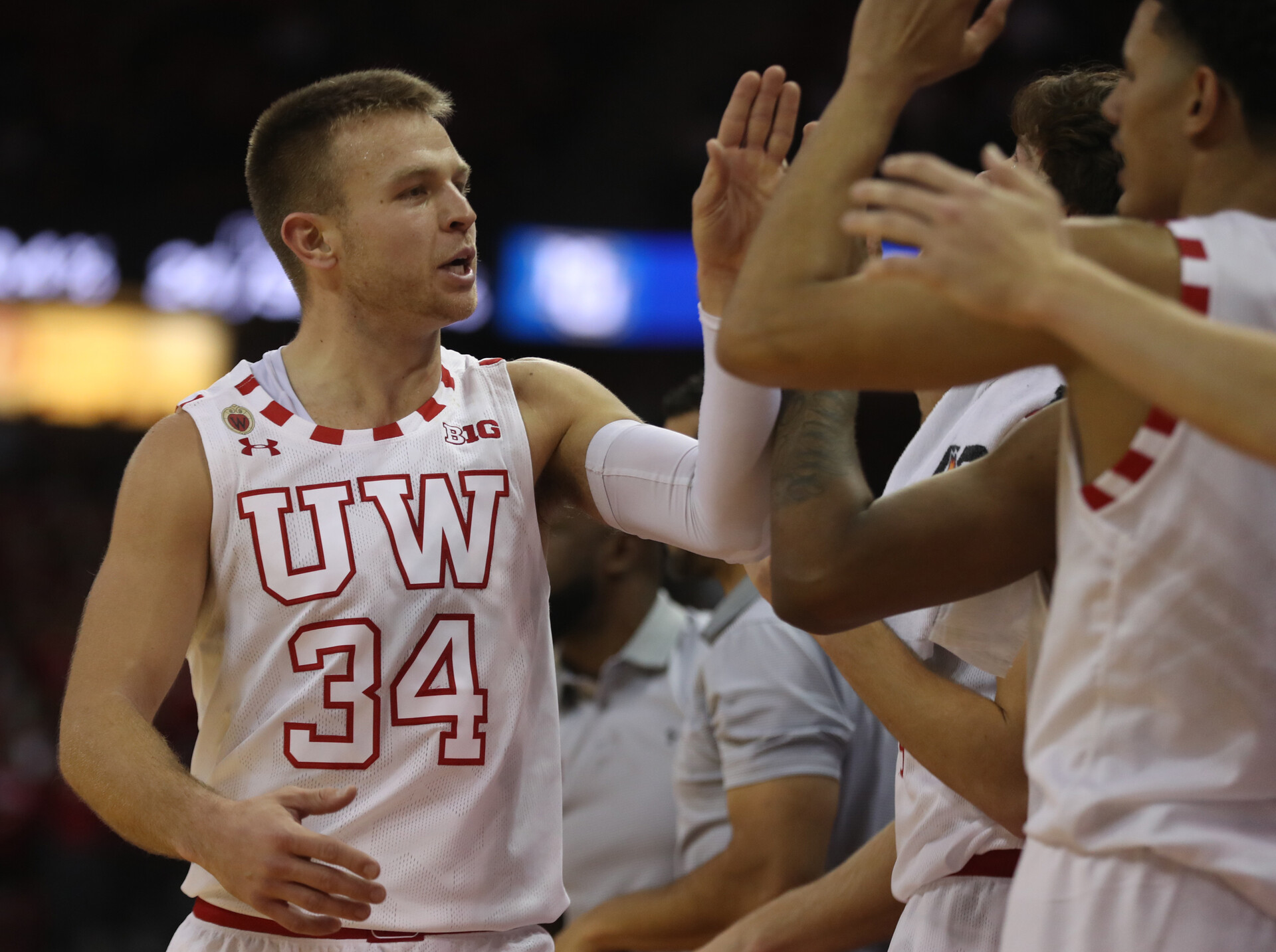 Wisconsin Badgers guard Brad Davison celebrates with teammates after returning to the bench near the end of a game against the Marquette Golden Eagles