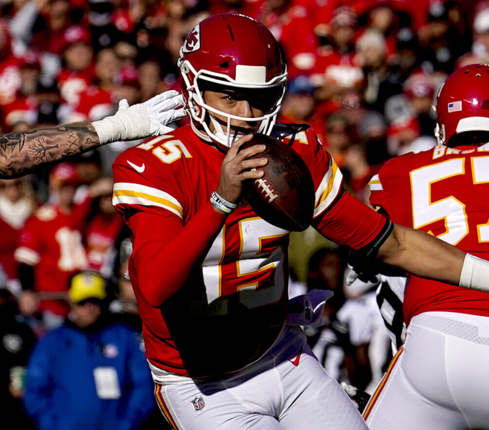 Dec 12, 2021; Kansas City, Missouri, USA; Kansas City Chiefs quarterback Patrick Mahomes (15) scrambles as Las Vegas Raiders defensive end Maxx Crosby (98) defends during the first half at GEHA Field at Arrowhead Stadium.
