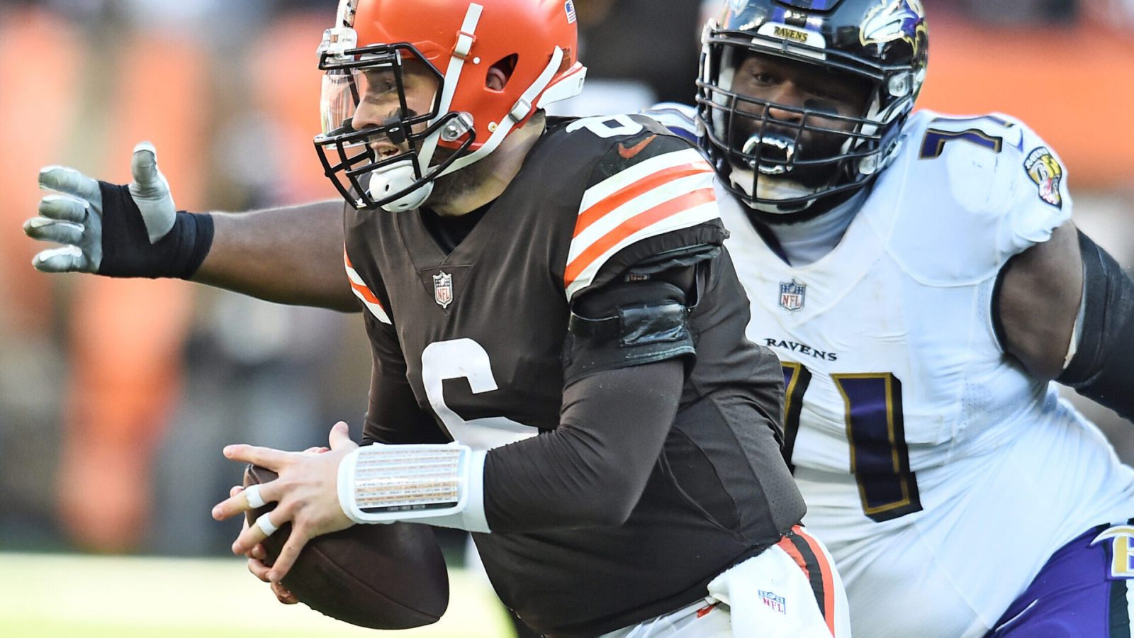 Baltimore Ravens nose tackle Justin Ellis (right) chases Cleveland Browns quarterback Baker Mayfield (left) during a game