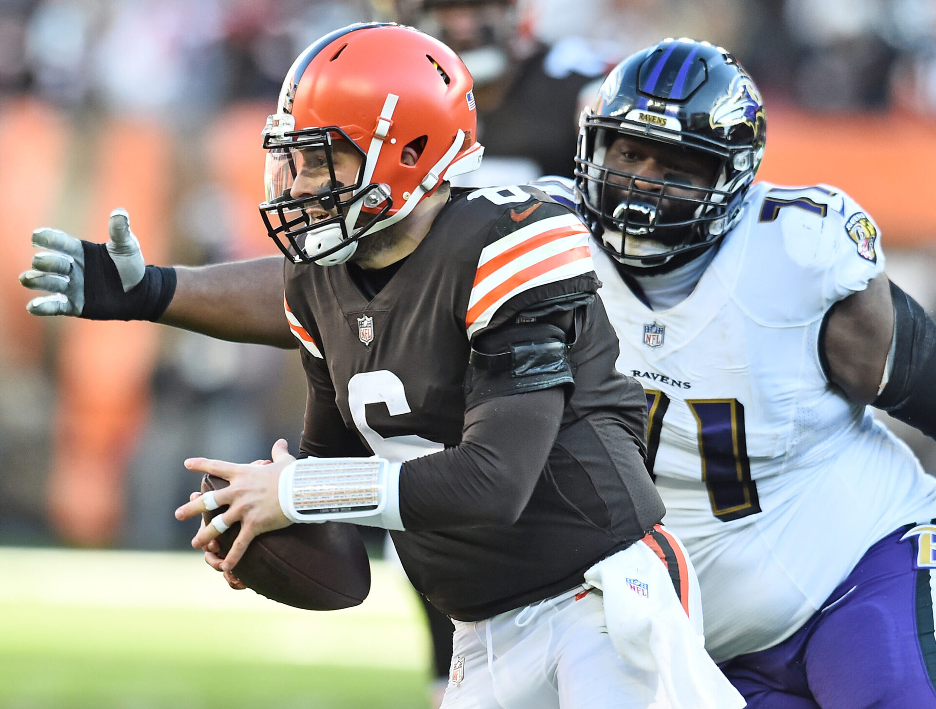 Baltimore Ravens nose tackle Justin Ellis (right) chases Cleveland Browns quarterback Baker Mayfield (left) during a game