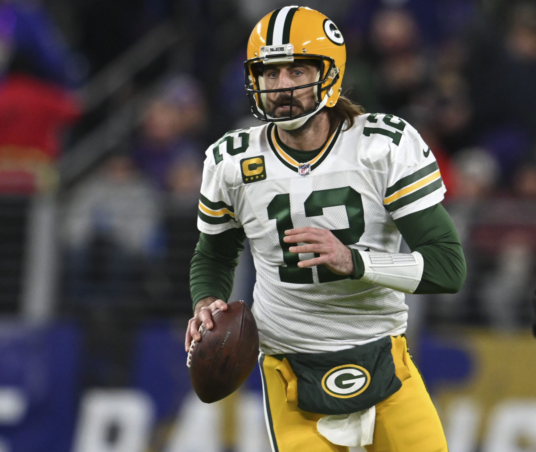 Green Bay Packers quarterback Aaron Rodgers looks to throw on the run against the Baltimore Ravens