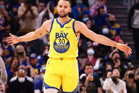 Golden State Warriors guard Stephen Curry celebrates with his arms outstretched after scoring a three-point basket against the Sacramento Kings