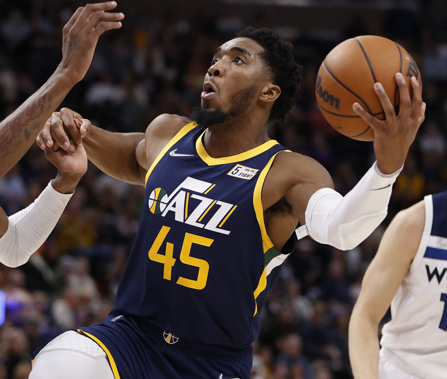 Dec 23, 2021; Salt Lake City, Utah, USA; Utah Jazz guard Donovan Mitchell (45) drives against Minnesota Timberwolves forward Jaden McDaniels (3) and forward Jake Layman (10) in the third quarter at Vivint Arena. Mandatory Credit: Jeffrey Swinger-USA TODAY Sports