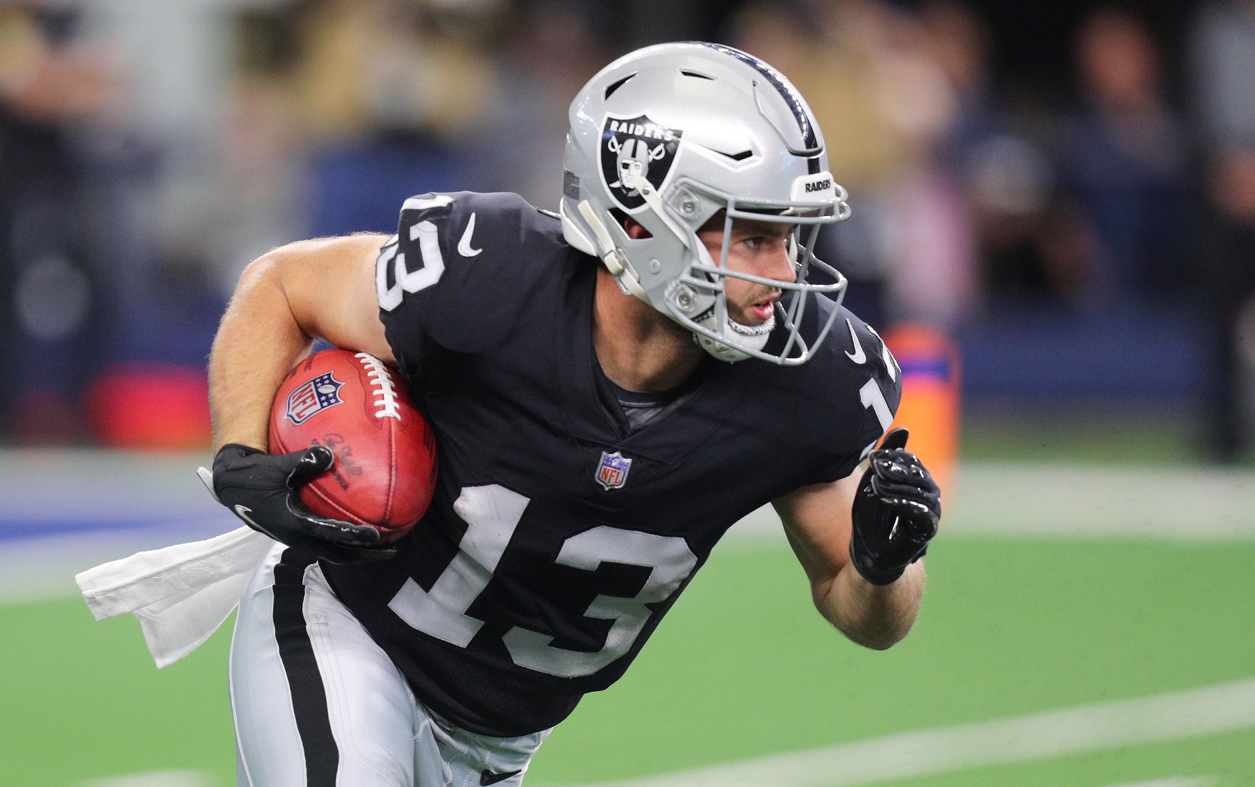 Hunter Renfrow #13 of the Las Vegas Raiders carries the ball after a punt return during the first quarter of the NFL game between Las Vegas Raiders and Dallas Cowboys at AT&T Stadium on November 25, 2021 in Arlington, Texas.
