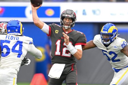 Tampa Bay Buccaneers quarterback Tom Brady throws a pass while getting pressured by Los Angeles Rams defensive players