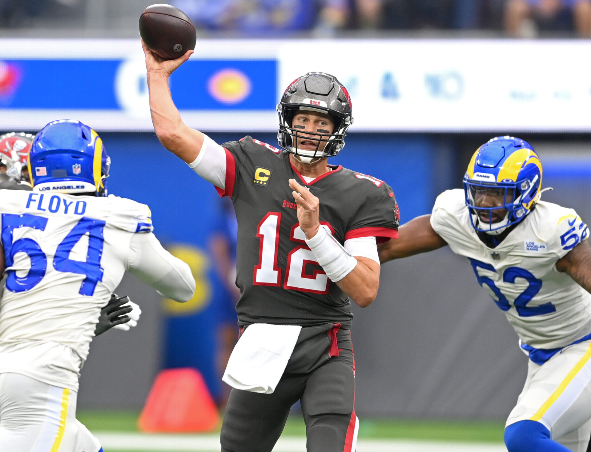 Tampa Bay Buccaneers quarterback Tom Brady throws a pass while getting pressured by Los Angeles Rams defensive players