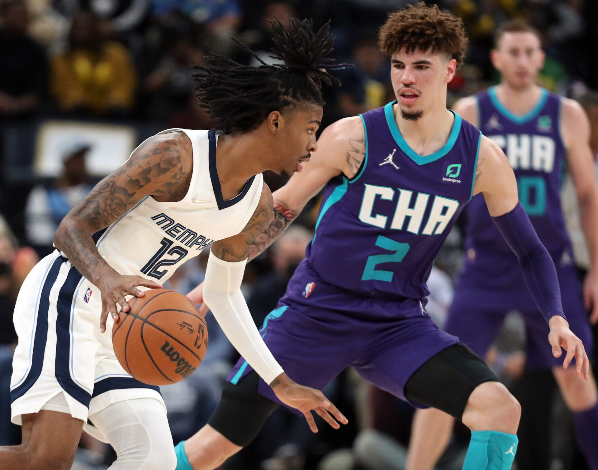 Memphis Grizzles guard Ja Morant (left) dribbles as Charlotte Hornets guard LaMelo Ball (right) defends