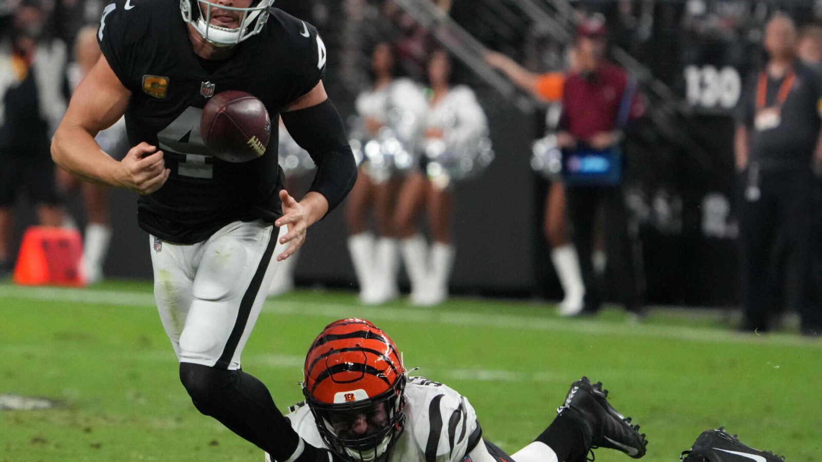 Cincinnati Bengals defensive end Trey Hendrickson (right) forces a fumble by Las Vegas Raiders quarterback Derek Carr (left)
