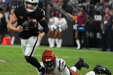 Cincinnati Bengals defensive end Trey Hendrickson (right) forces a fumble by Las Vegas Raiders quarterback Derek Carr (left)