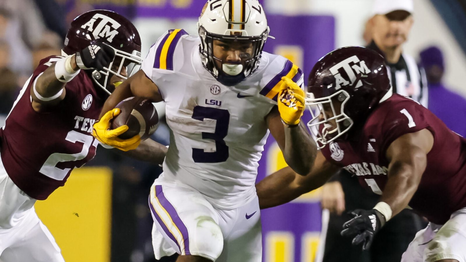 Nov 27, 2021; Baton Rouge, Louisiana, USA; LSU Tigers running back Tyrion Davis-Price (3) runs between Texas A&M Aggies defensive back Antonio Johnson (27) and linebacker Aaron Hansford (1) during the first half at Tiger Stadium. Mandatory Credit: Stephen Lew-USA TODAY Sports