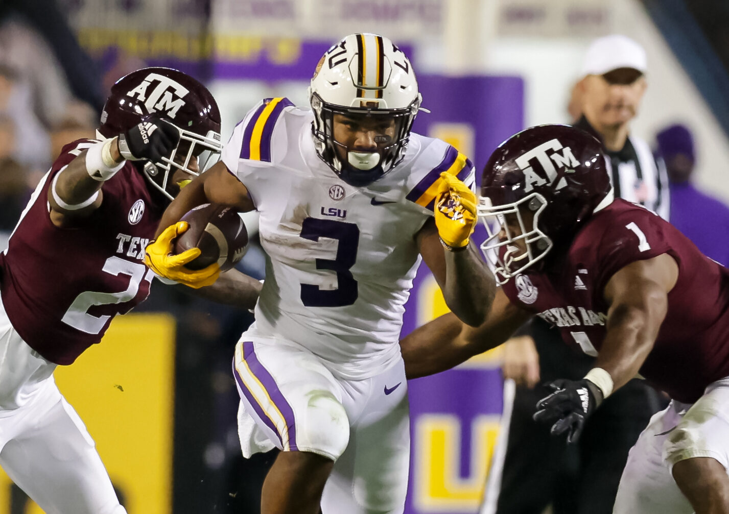 Nov 27, 2021; Baton Rouge, Louisiana, USA; LSU Tigers running back Tyrion Davis-Price (3) runs between Texas A&M Aggies defensive back Antonio Johnson (27) and linebacker Aaron Hansford (1) during the first half at Tiger Stadium. Mandatory Credit: Stephen Lew-USA TODAY Sports