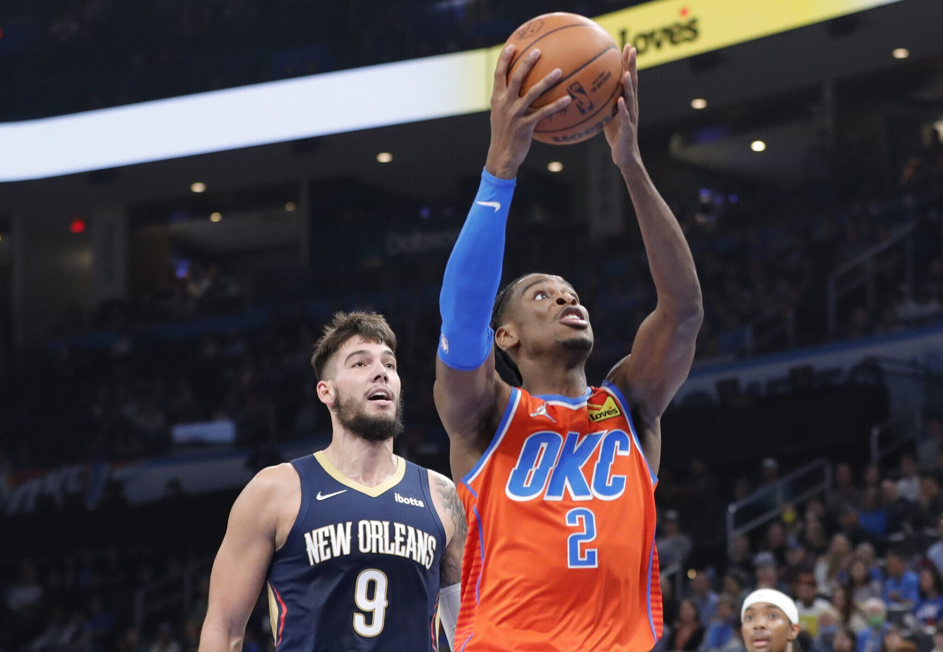Oklahoma City Thunder guard Shai Gilgeous-Alexander (center) goes up for a basket ahead of New Orleans Pelicans center Willy Hernangomez (left)