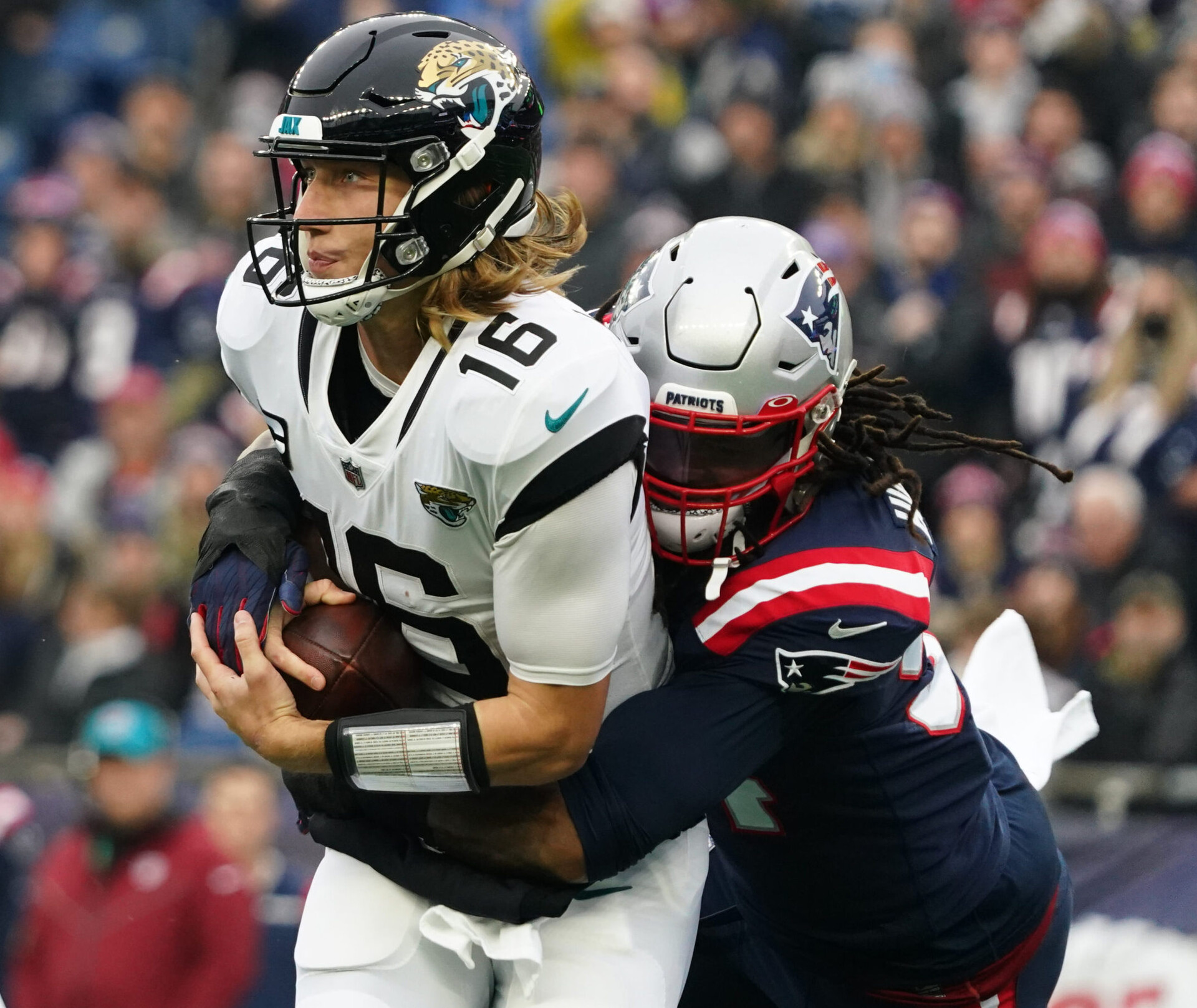 Jacksonville Jaguars quarterback Trevor Lawrence (left) is sacked by New England Patriots outside linebacker Dont'a Hightower (right)
