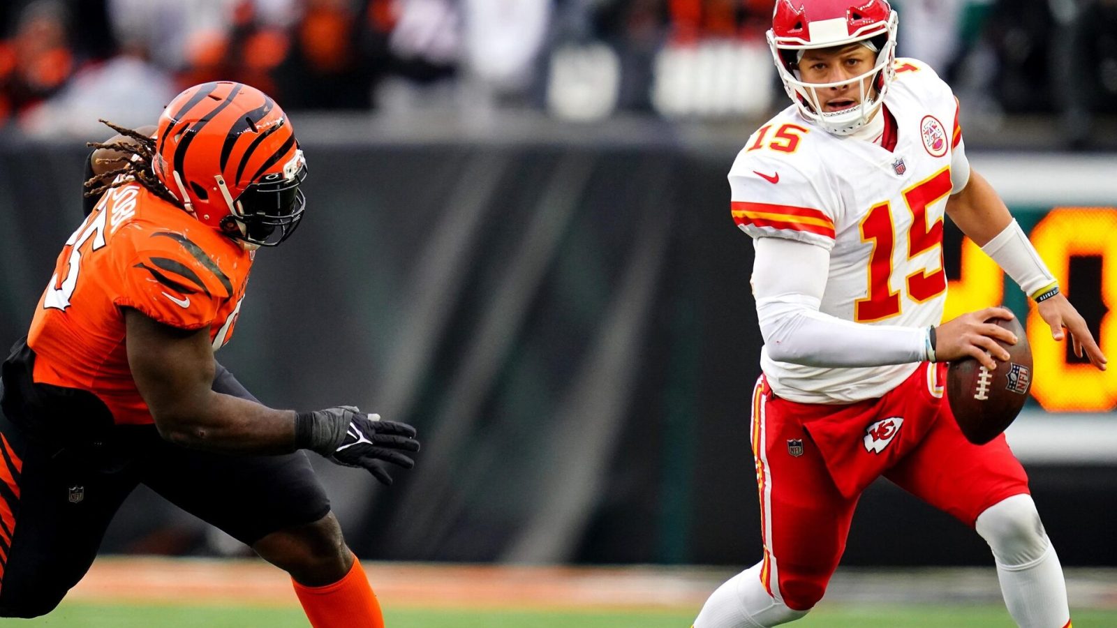 Kansas City Chiefs quarterback Patrick Mahomes (right) is chased out of the pocket by Cincinnati Bengals defensive tackle Larry Ogunjobi (left)