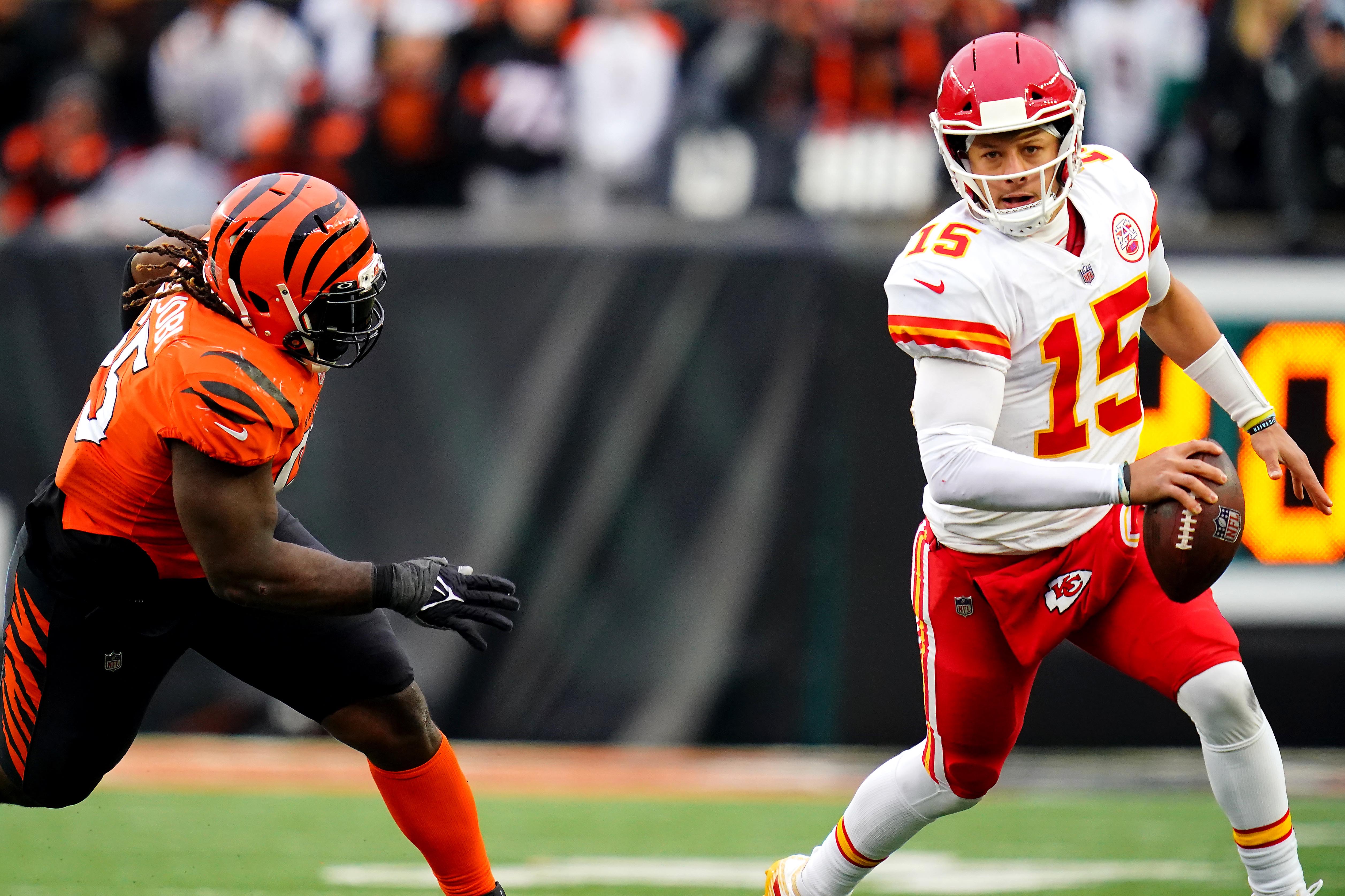 Kansas City Chiefs quarterback Patrick Mahomes (right) is chased out of the pocket by Cincinnati Bengals defensive tackle Larry Ogunjobi (left)