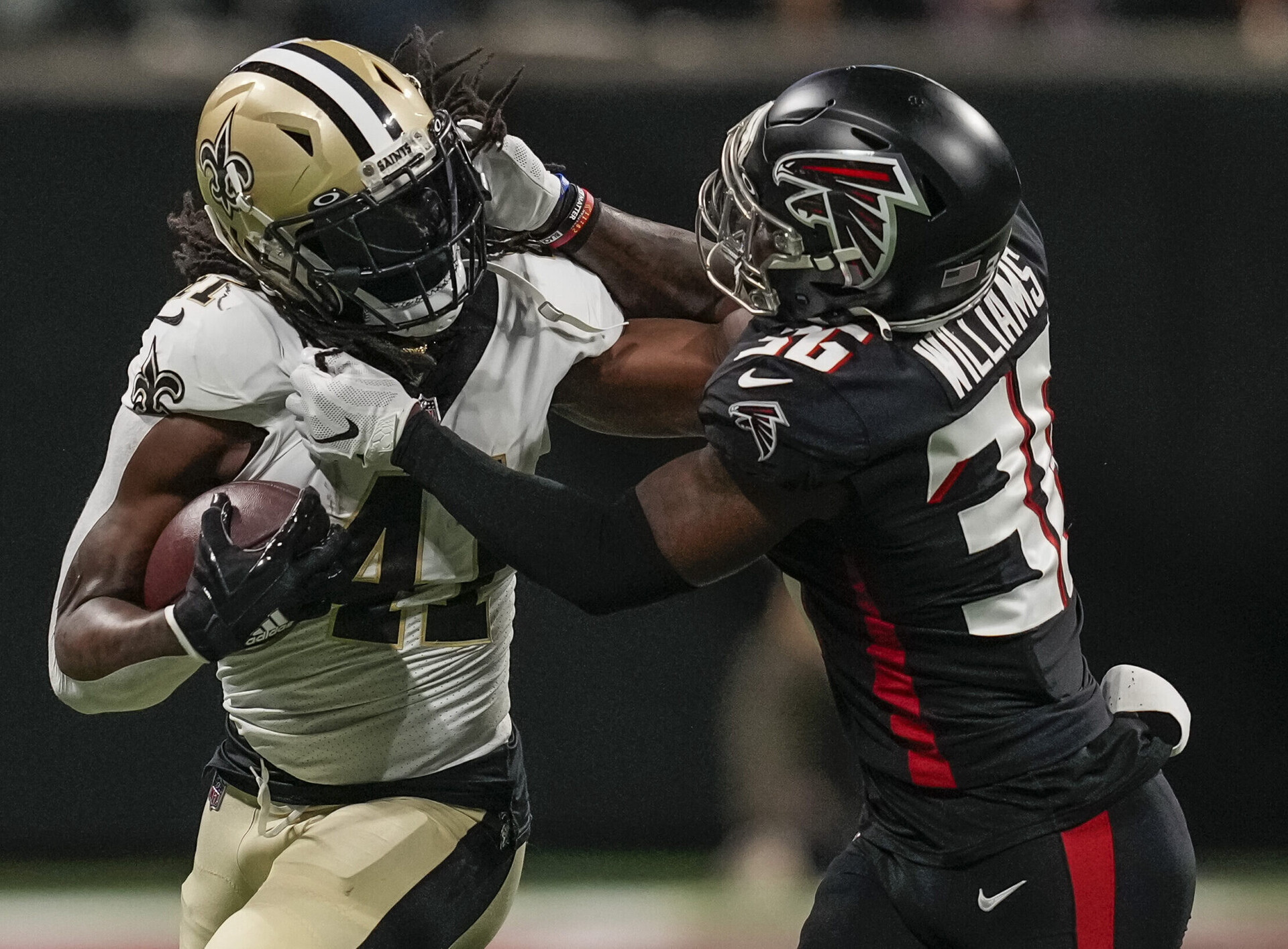 New Orleans Saints running back Alvin Kamara (left) tries to break the tackle of Atlanta Falcons safety Shawn Williams (right)