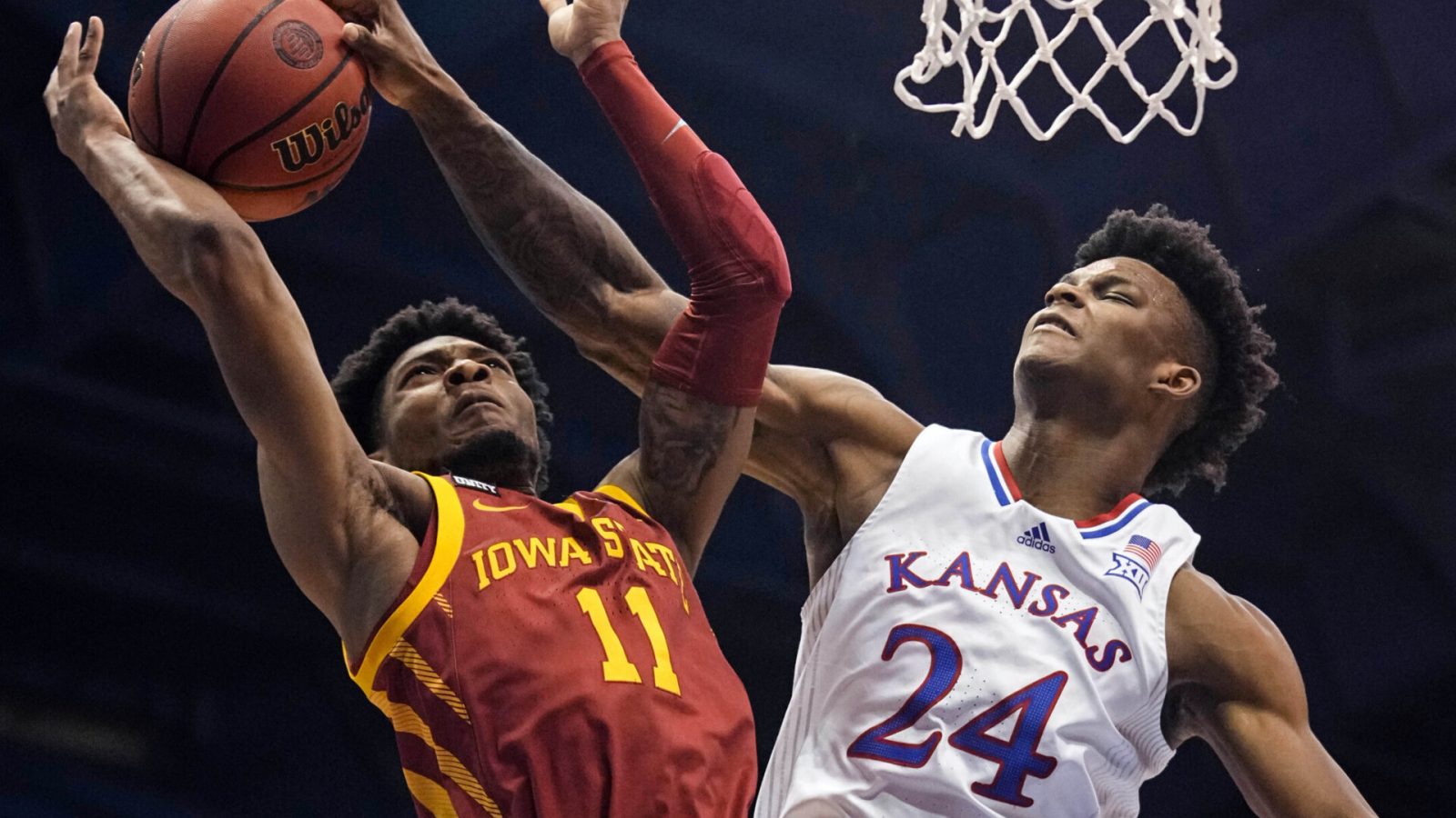 Kansas Jayhawks forward K.J. Adams (right) blocks the shot of Iowa State Cyclones guard Tyrese Hunter (left) during a Big 12 basketball game.