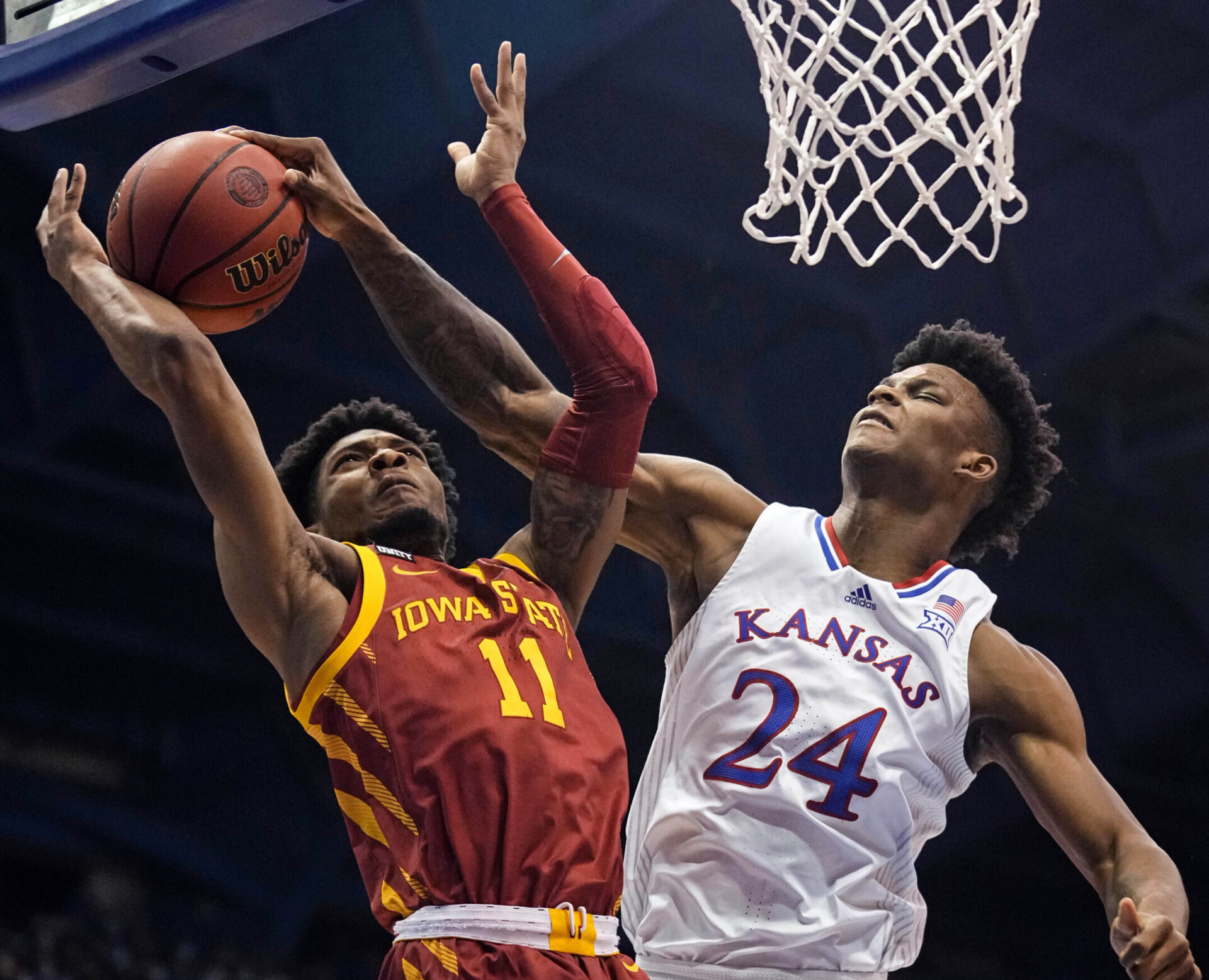 Kansas Jayhawks forward K.J. Adams (right) blocks the shot of Iowa State Cyclones guard Tyrese Hunter (left) during a Big 12 basketball game.