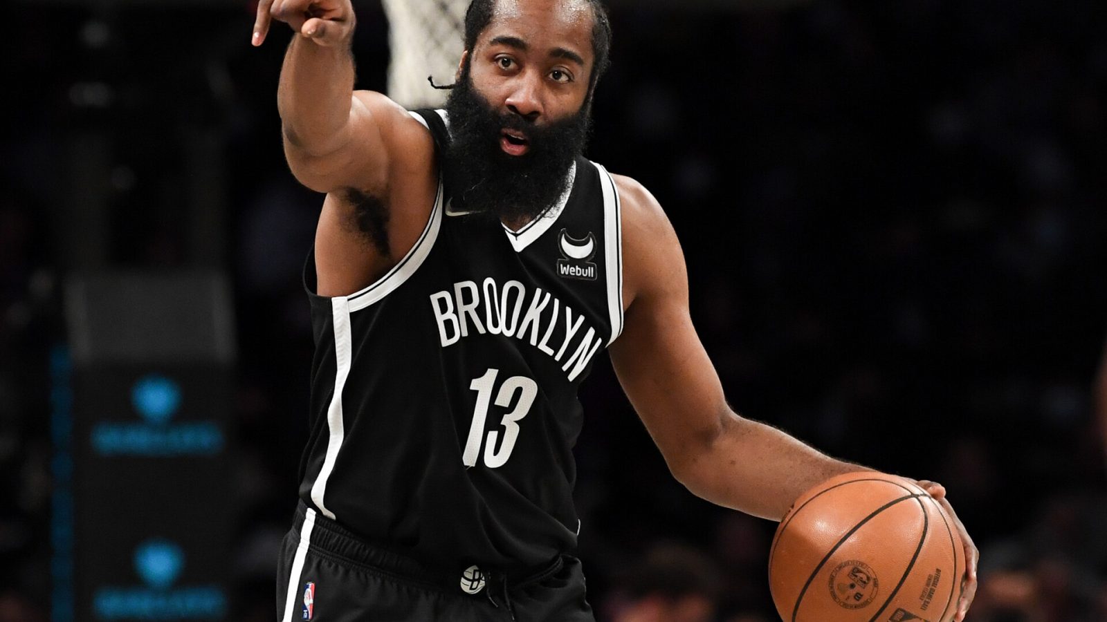 Brooklyn Nets guard James Harden directs his team with his right hand while dribbling the basketball with his left hand against the New Orleans Pelicans