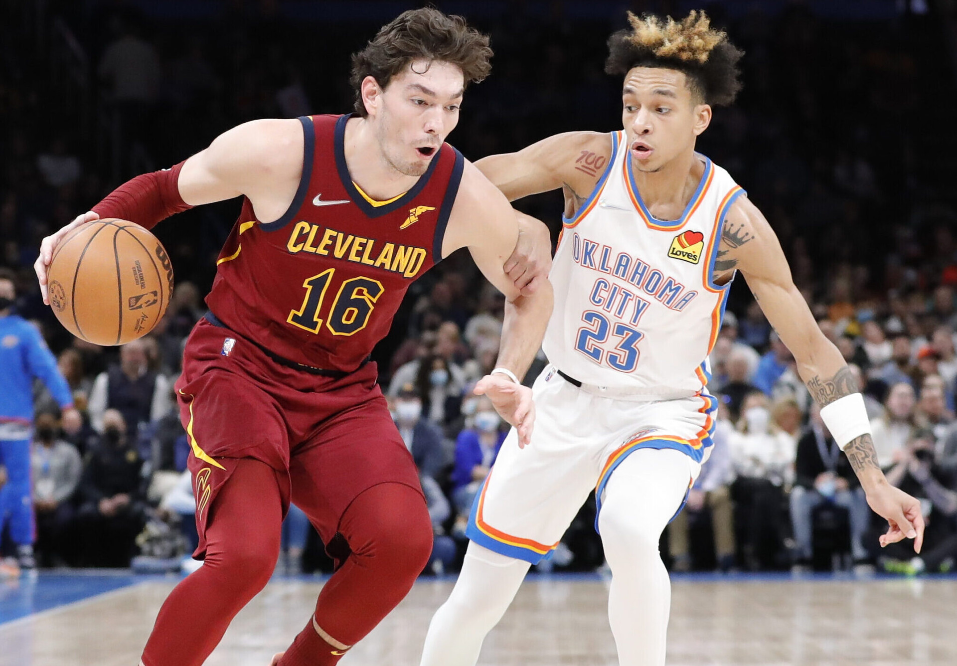 Cleveland Cavaliers forward Cedi Osman (left) drives to the basket around Oklahoma City Thunder guard Tre Mann (right)