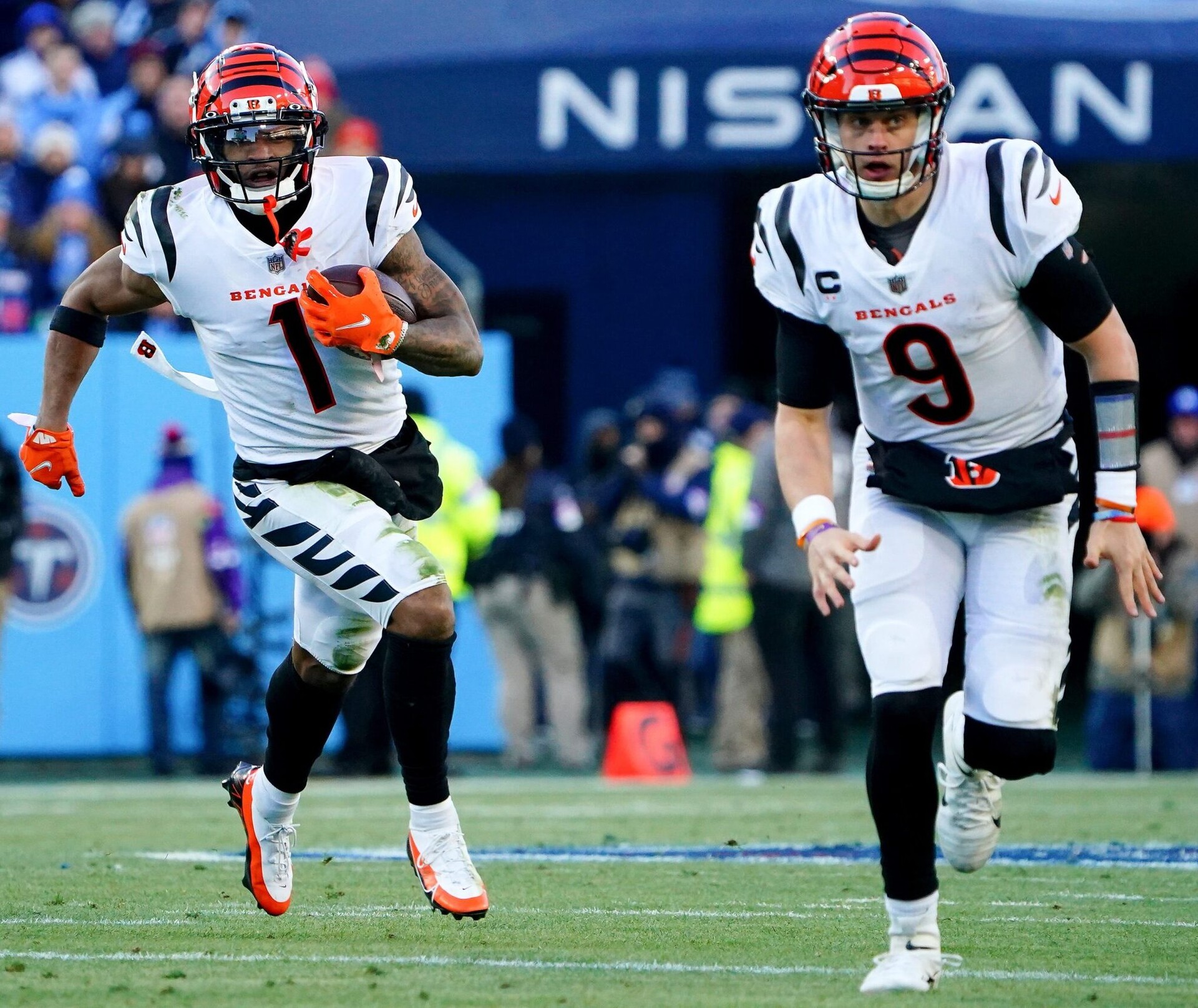 Cincinnati Bengals wide receiver Ja'Marr Chase (1) carries the ball as Cincinnati Bengals quarterback Joe Burrow (9) blocks in the first quarter during an NFL divisional playoff football game against the Tennessee Titans, Saturday, Jan. 22, 2022, at Nissan Stadium in Nashville. Cincinnati Bengals At Tennessee Titans Jan 22 Afc Divisional Playoffs