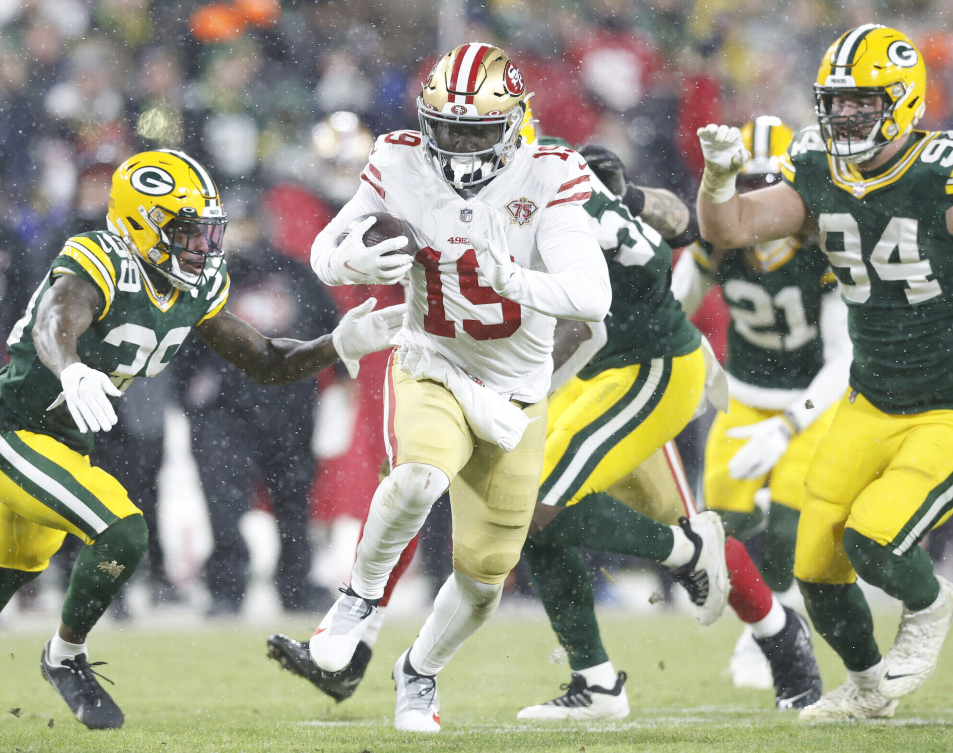 Jan 22, 2022; Green Bay, Wisconsin, USA; San Francisco 49ers wide receiver Deebo Samuel (19) carries the ball past Green Bay Packers defensive end Dean Lowry (94) and Packers defensive back Chandon Sullivan (39) in the third quarter during a NFC Divisional playoff football game at Lambeau Field.