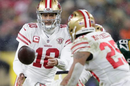 San Francisco 49ers quarterback Jimmy Garoppolo (10) tosses the ball top running back Elijah Mitchell (25) against the Green Bay Packers in the third quarter during their NFL divisional round football playoff game Saturday January 22, 2022, at Lambeau Field in Green Bay, Wis.