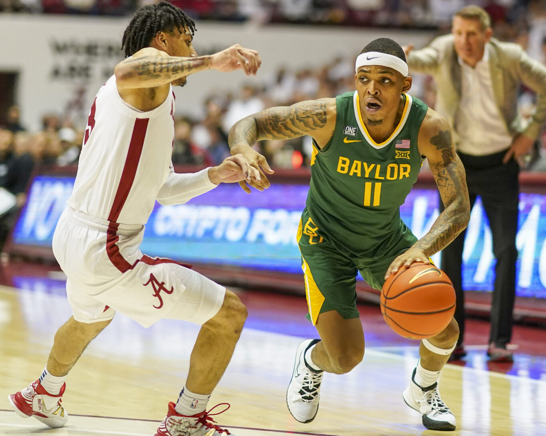 Baylor Bears guard James Akinjo (right) controls the basketball against Alabama Crimson Tide guard Jahvon Quinerly (left)