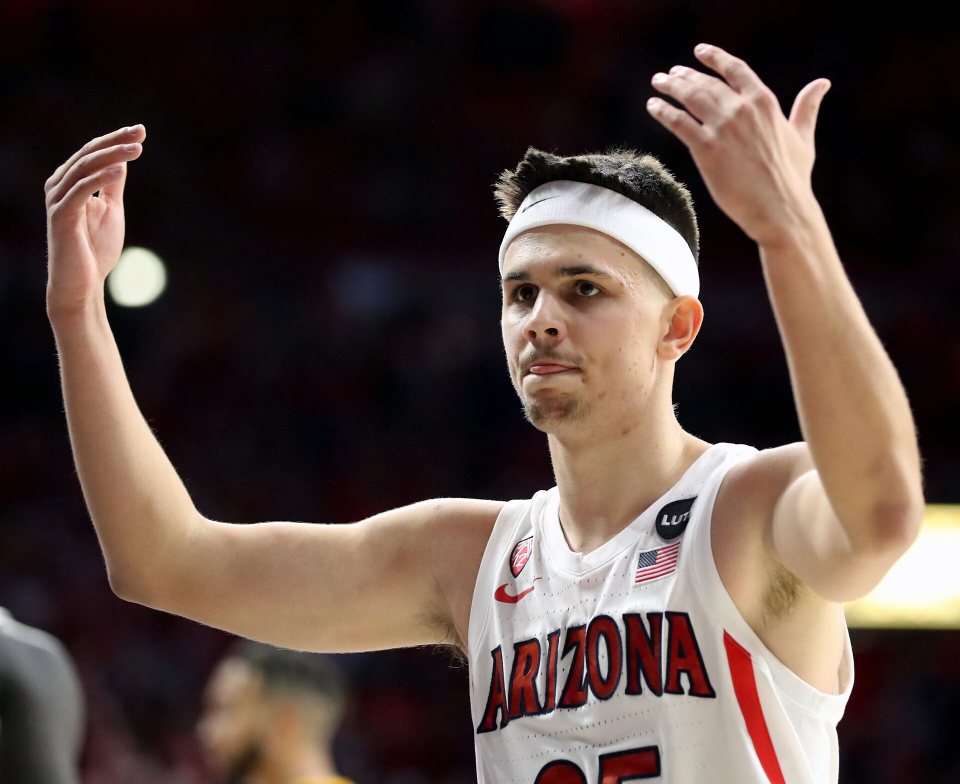 Arizona guard Kerr Kriisa encourages the crowd to make some noise during the second half of a Pac-12 basketball game between the USC Trojans