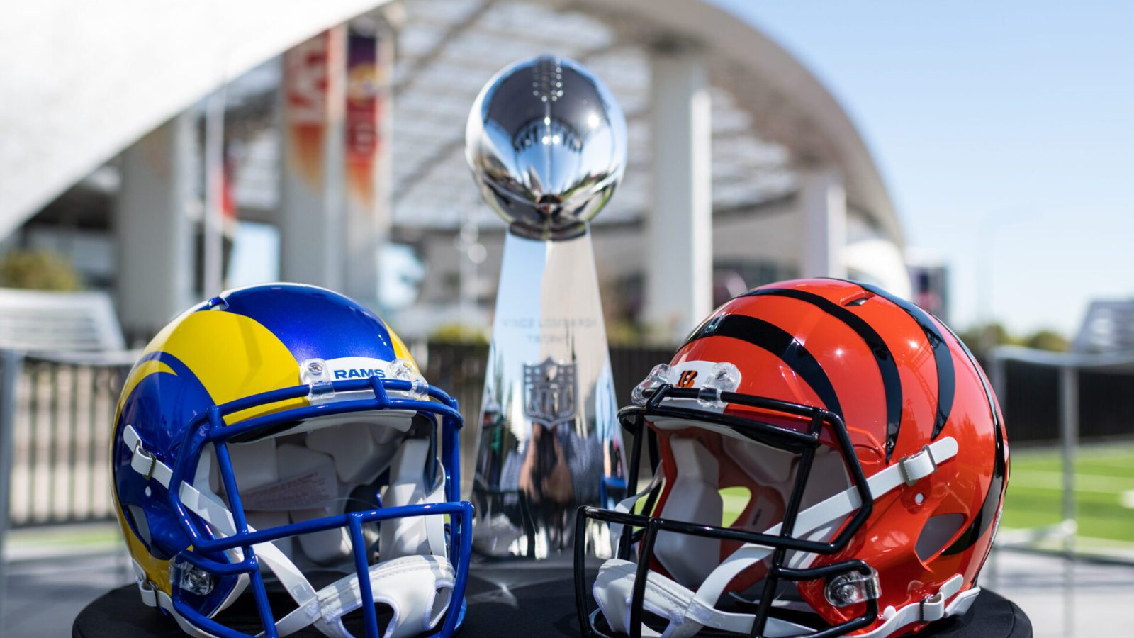 The helmets of the Super Bowl participants Los Angeles Rams (left) and Cinncinati Bengals (right) stand on a table in front of the Vince Lombardy Trophy, which the winner receives
