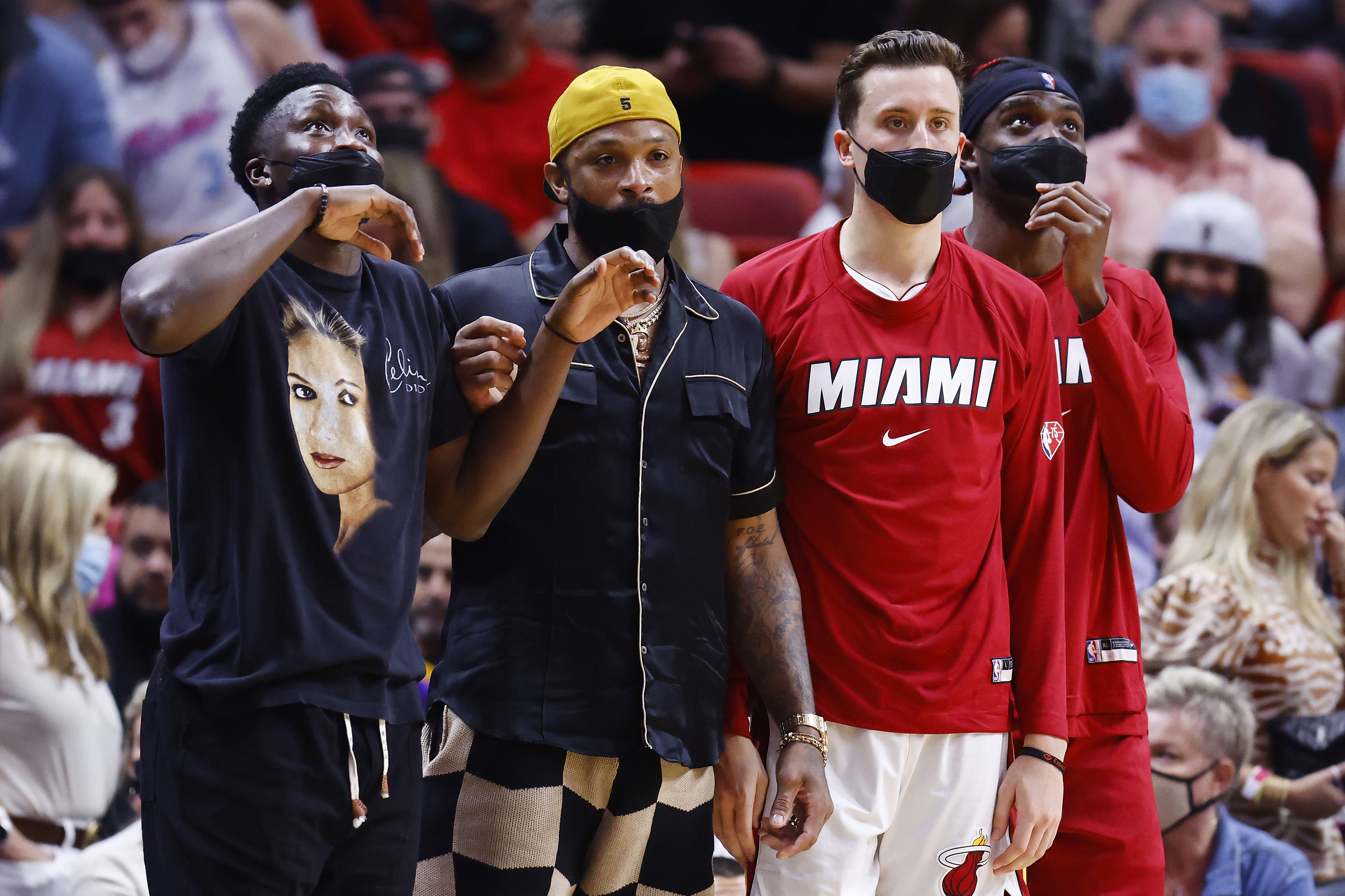 Victor Oladipo #4, P.J. Tucker #17, Duncan Robinson #55 and Zylan Cheatham #45 of the Miami Heat look on against the Washington Wizards during the first half at FTX Arena on December 28, 2021 in Miami, Florida.