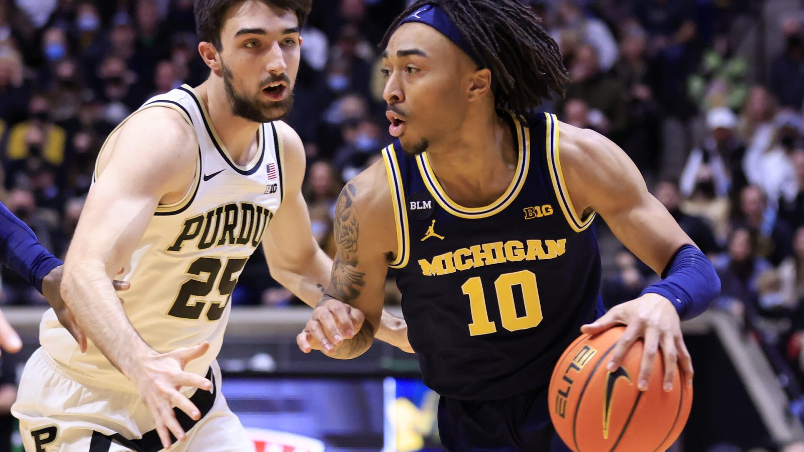 Michigan Wolverines player Frankie Collins drives to the basket while guarded by Purdue's in a Big Ten basketball game.