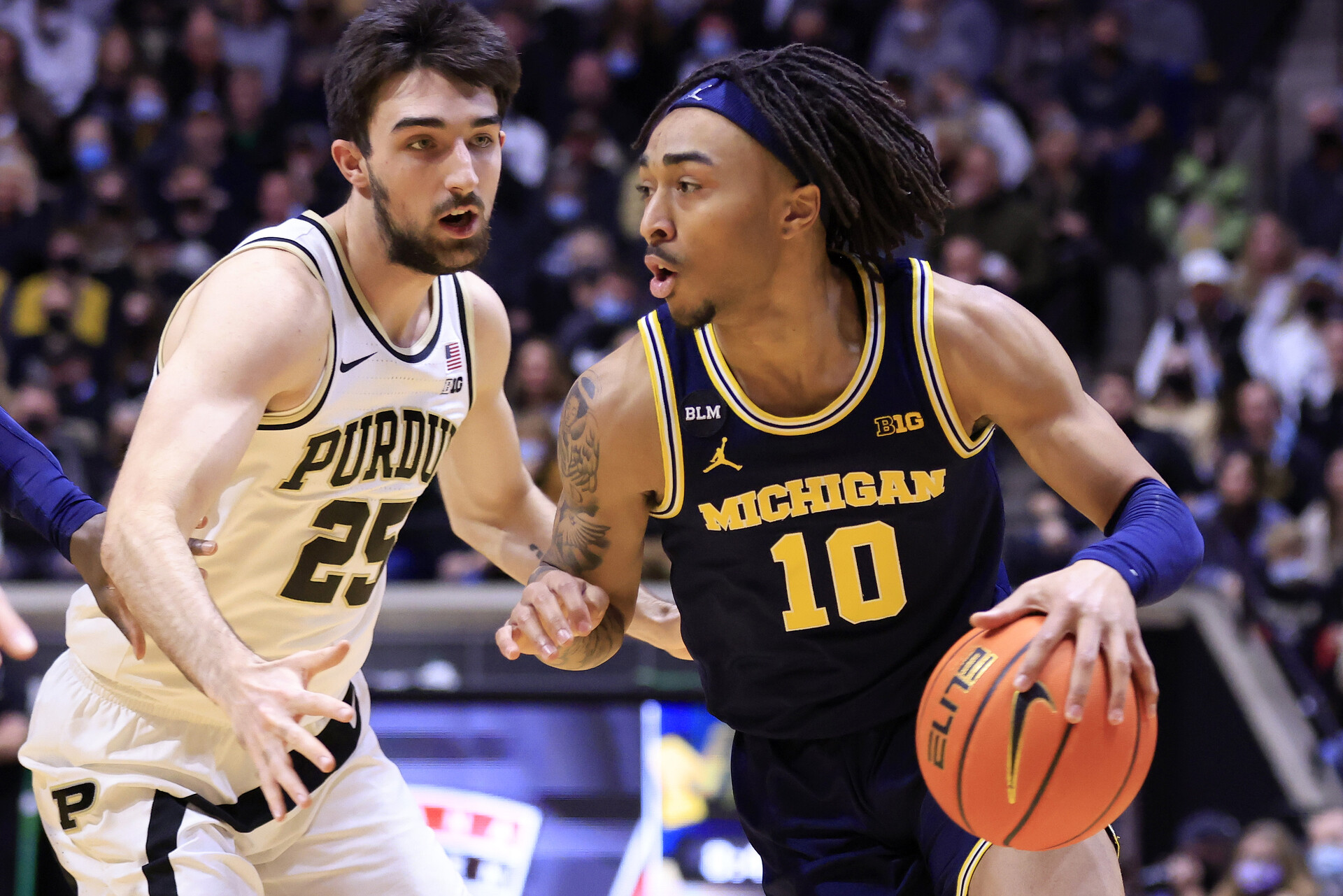 Michigan Wolverines player Frankie Collins drives to the basket while guarded by Purdue's in a Big Ten basketball game.