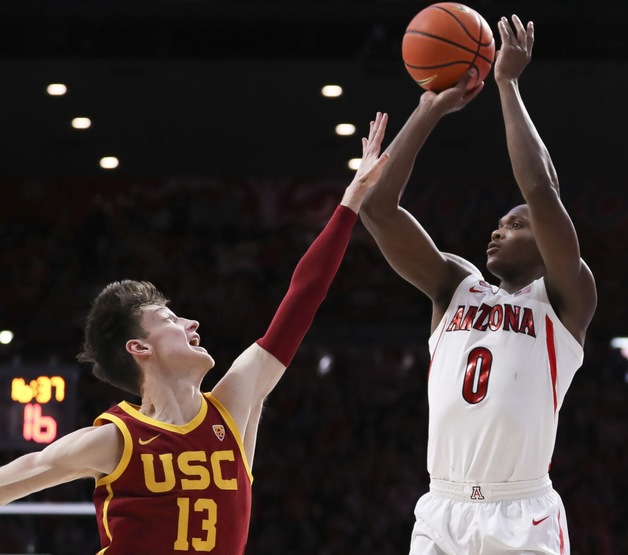 Arizona Wildcats guard Bennedict Mathurin (right) shoots over USC guard Drew Peterson (left) during a Pac-12 basketball game