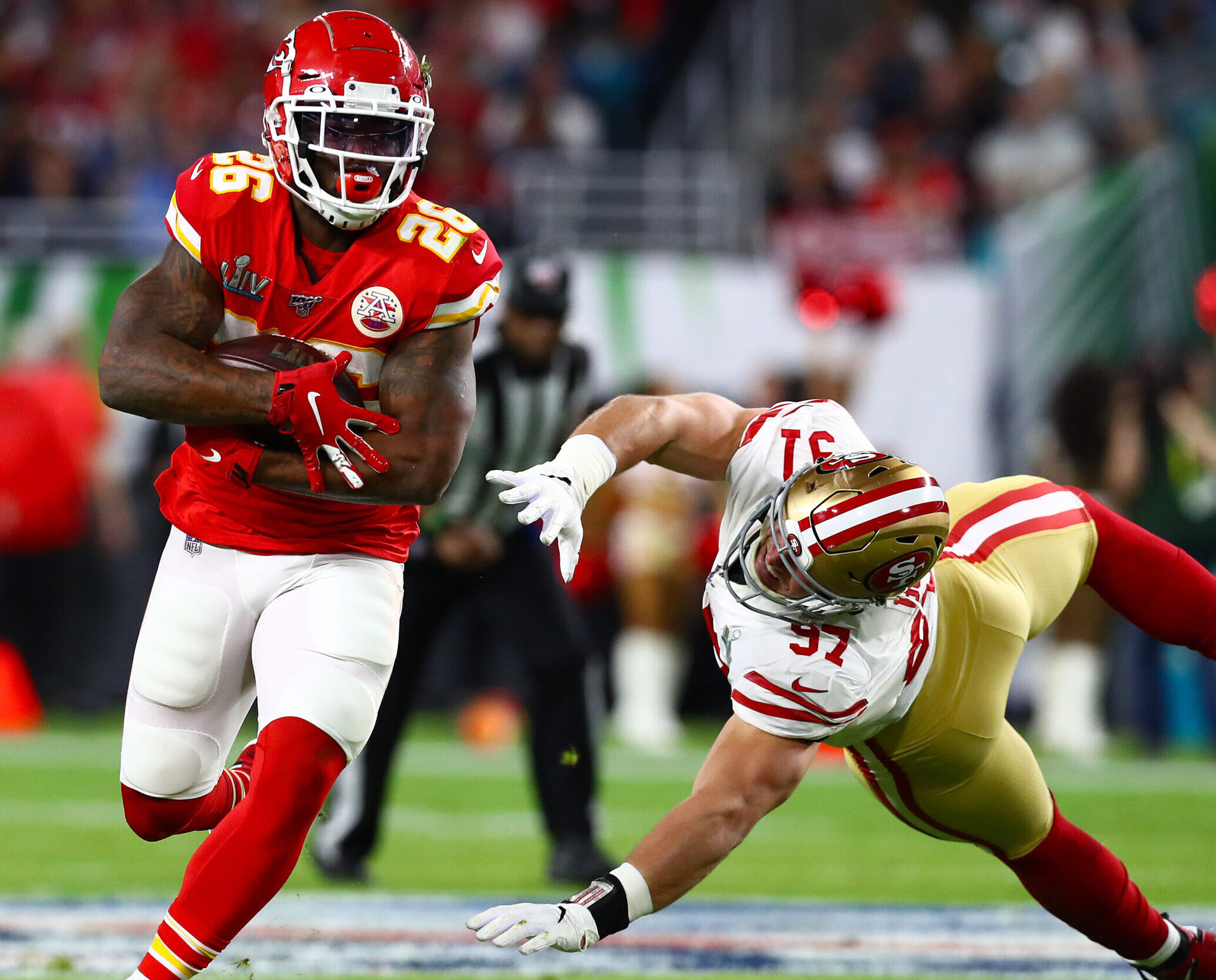 Kansas City Chiefs running back Damien Williams (left) eludes a tackle attempt by San Francisco 49ers defensive end Nick Bosa (right) in Super Bowl LIV