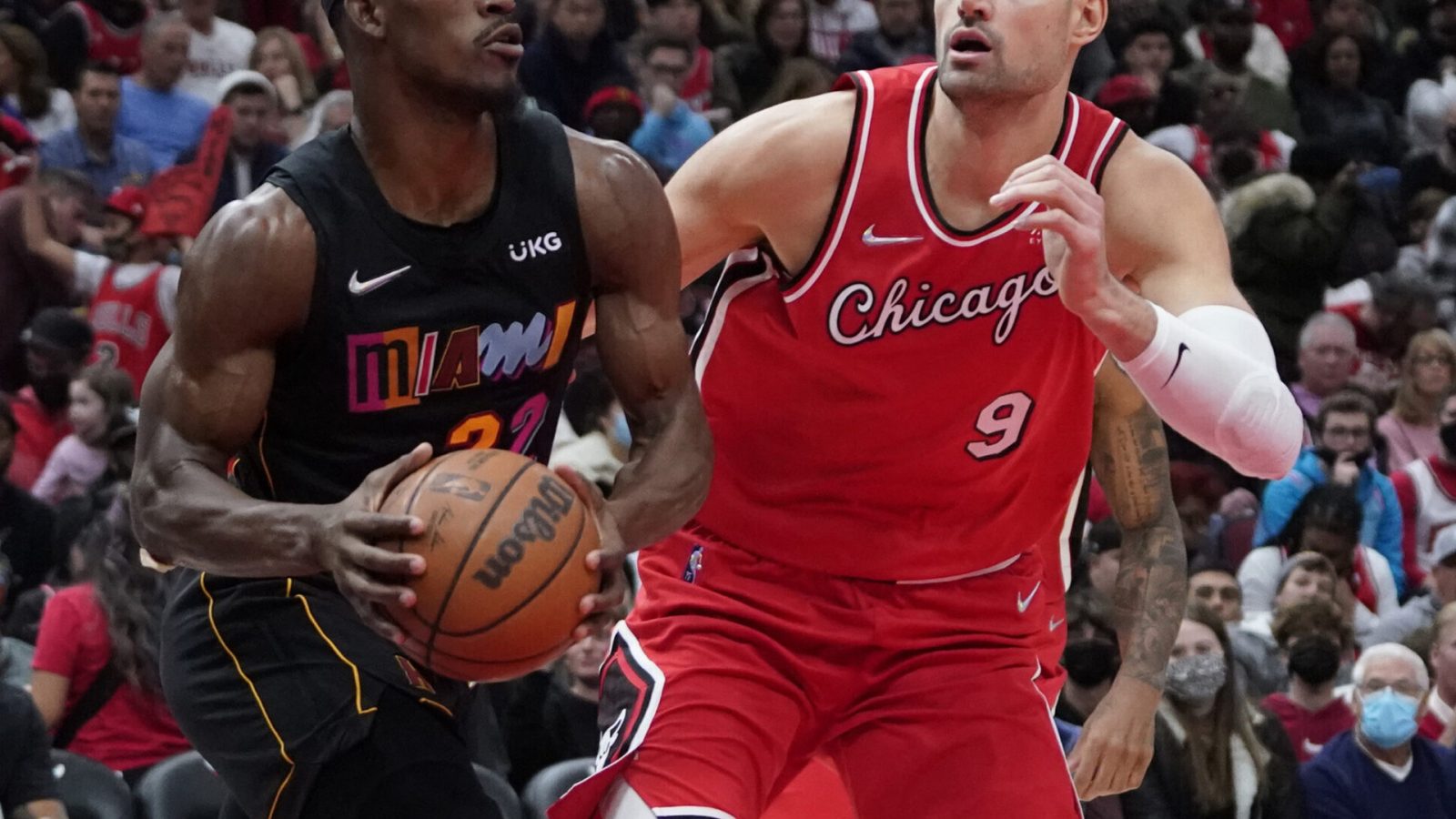 Miami Heat forward Jimmy Butler (left) starts to make a move to the basket while being defended by Chicago Bulls center Nikola Vucevic
