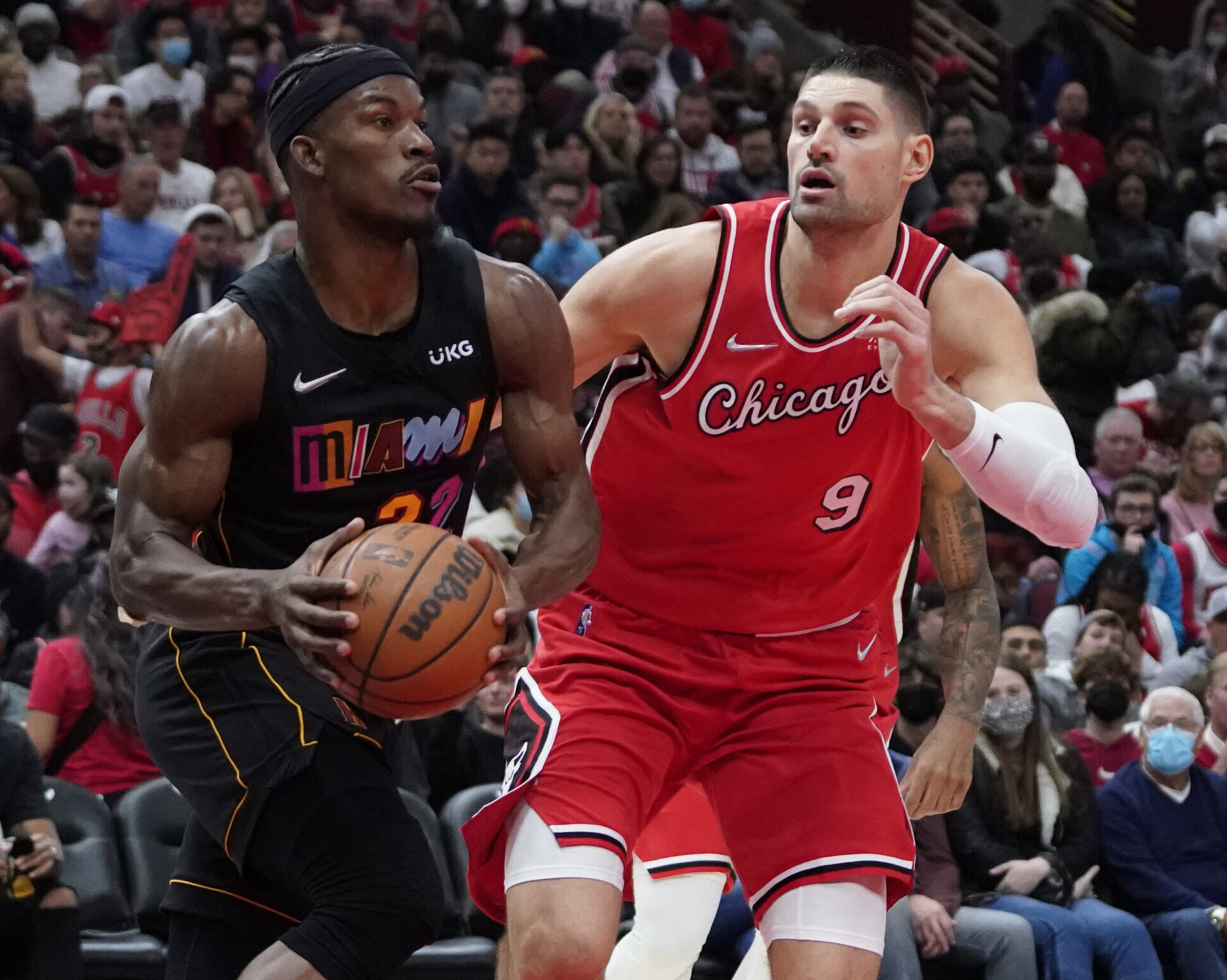 Miami Heat forward Jimmy Butler (left) starts to make a move to the basket while being defended by Chicago Bulls center Nikola Vucevic