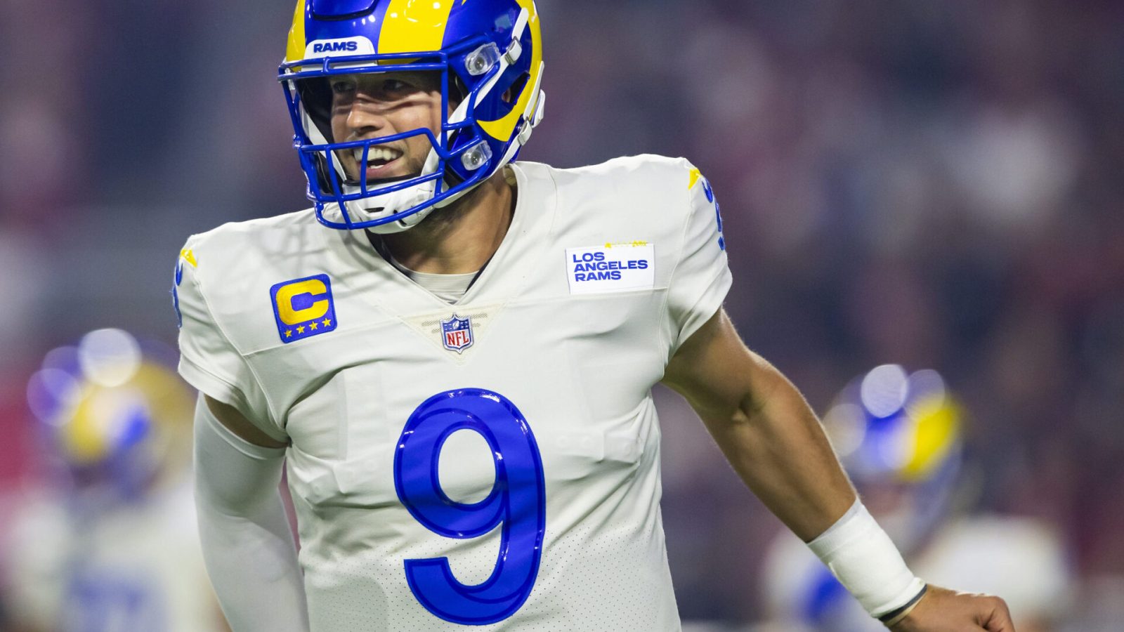 Los Angeles Rams quarterback Matthew Stafford smiles while jogging off the field during a game against the Arizona Cardinals