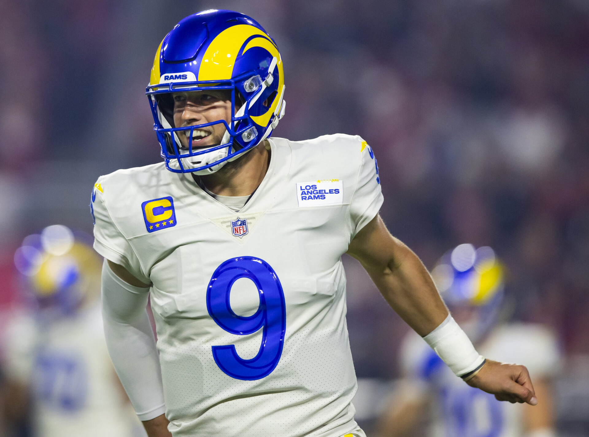 Los Angeles Rams quarterback Matthew Stafford smiles while jogging off the field during a game against the Arizona Cardinals