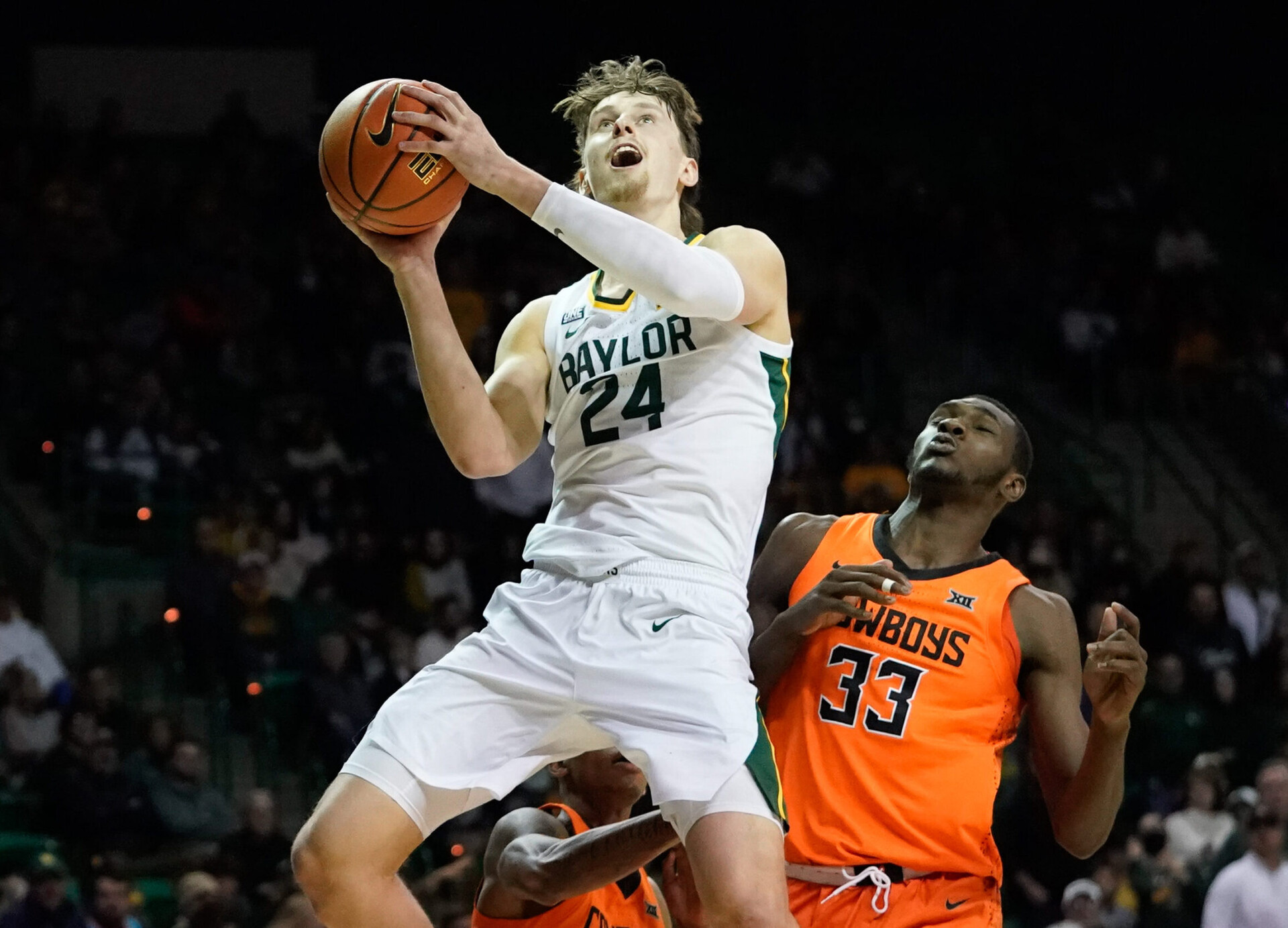 Baylor Bears guard Matthew Mayer (left) prepares to take a shot while driving to the basket as Oklahoma State Cowboys forward Moussa Cisse (right) defends
