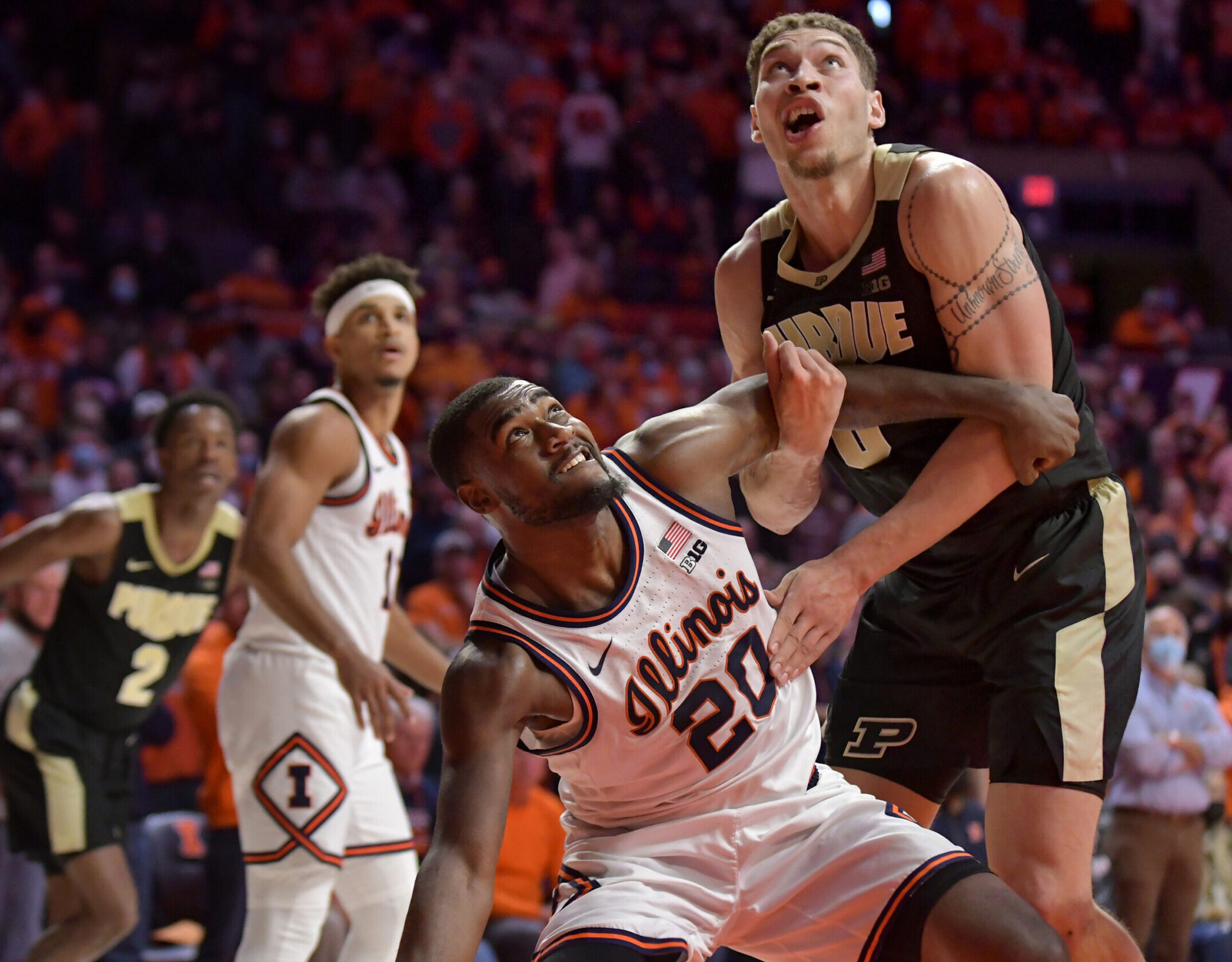 Illinois Fighting Illini guard Da'Monte Williams (left) and Purdue Boilermakers forward Mason Gillis (right) battle for position under the basket during a Big Ten basketball game
