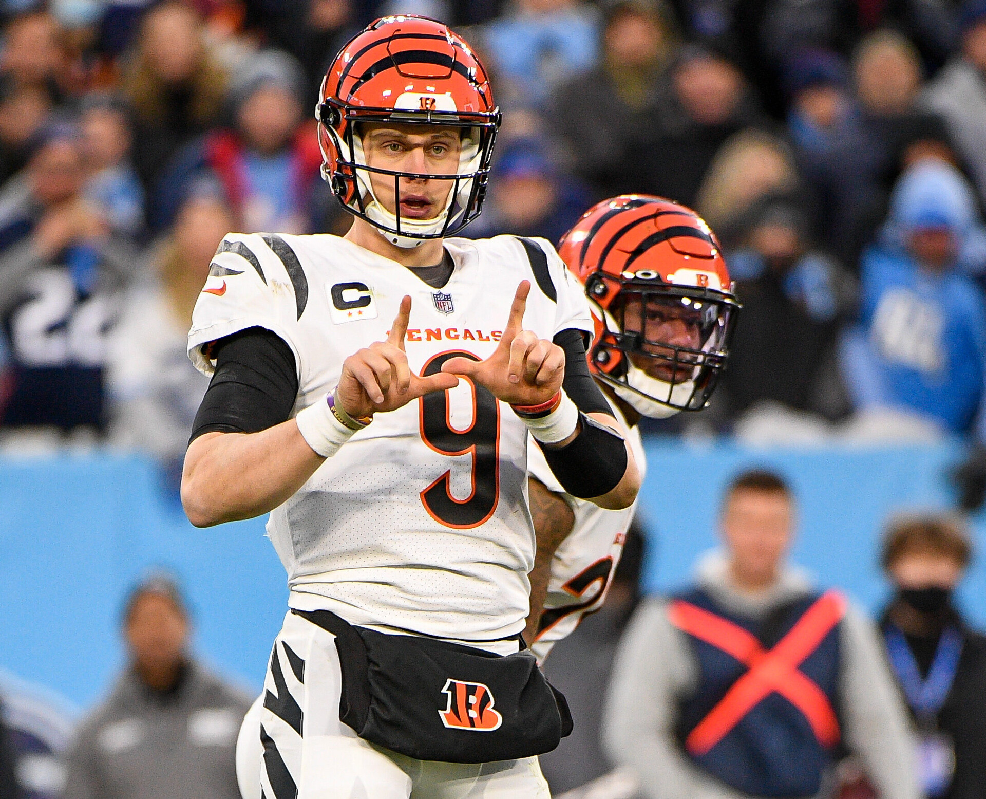 Cincinnati Bengals quarterback Joe Burrow makes hand signals to teammates prior to a play against the Tennessee Titans in an AFC Divisional playoff football game