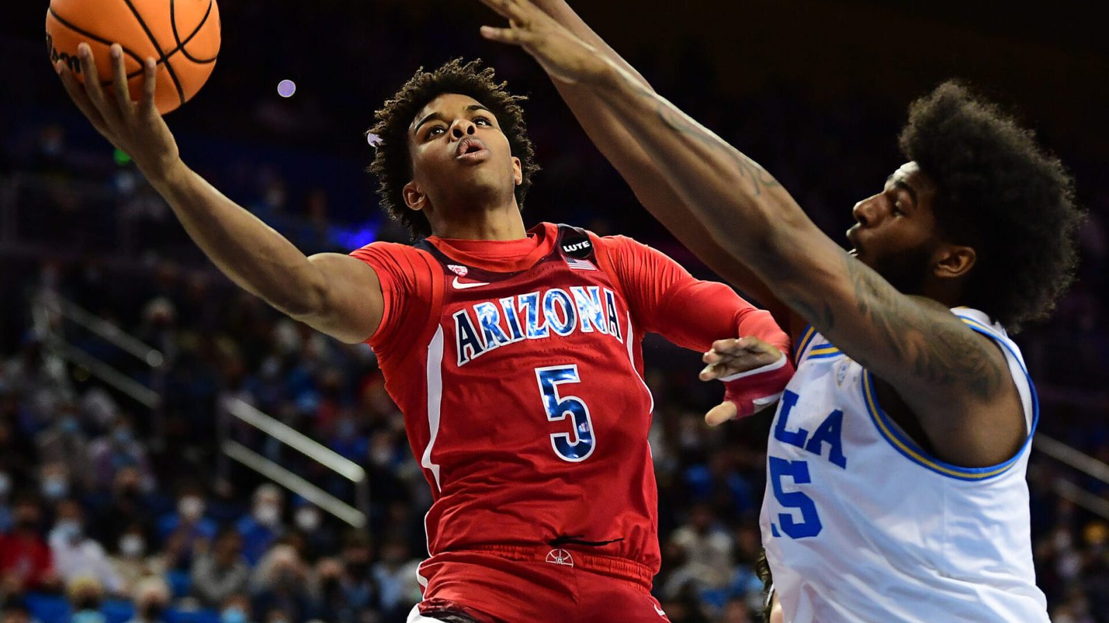 Arizona Wildcats guard Justin Kier (left) rises to take a shot while UCLA Bruins center Myles Johnson (right) defends during a Pac-12 Conference basketball game at UCLA