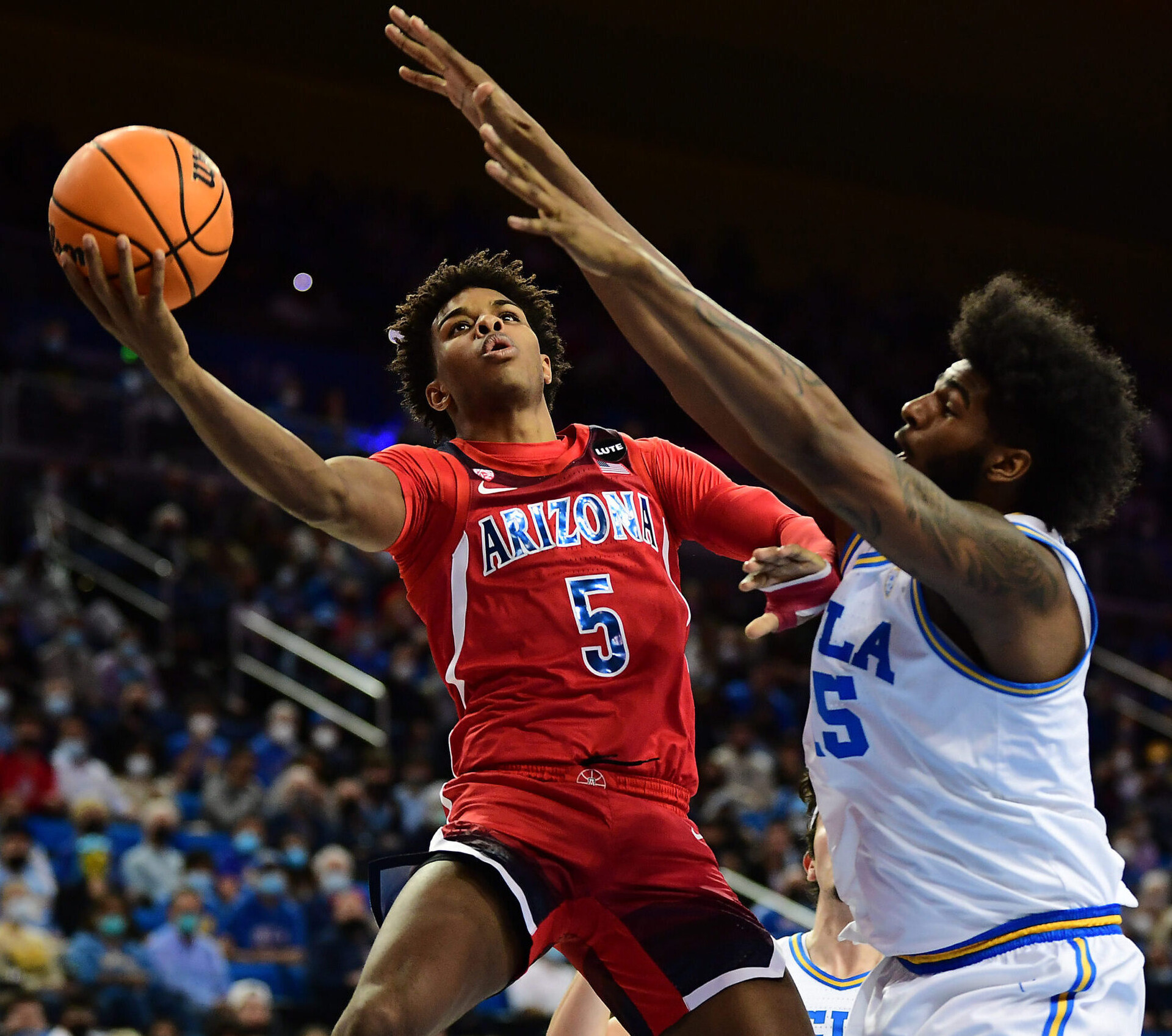 Arizona Wildcats guard Justin Kier (left) rises to take a shot while UCLA Bruins center Myles Johnson (right) defends during a Pac-12 Conference basketball game at UCLA