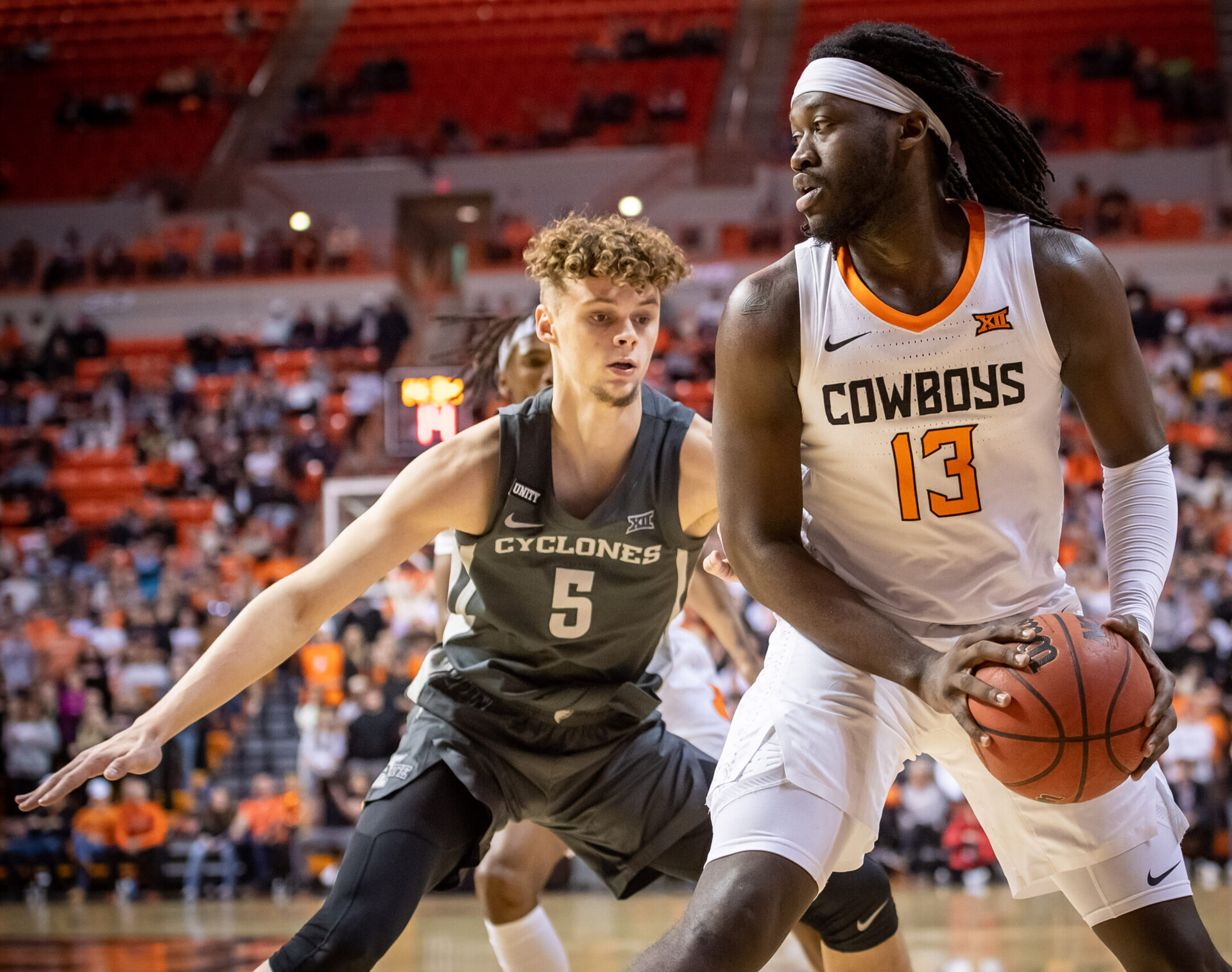 Oklahoma State Cowboys guard Isaac Likekele (right) controls the ball and looks to maneuver around Iowa State Cyclones forward Aljaz Kunc (left) during a Big 12 basketball game